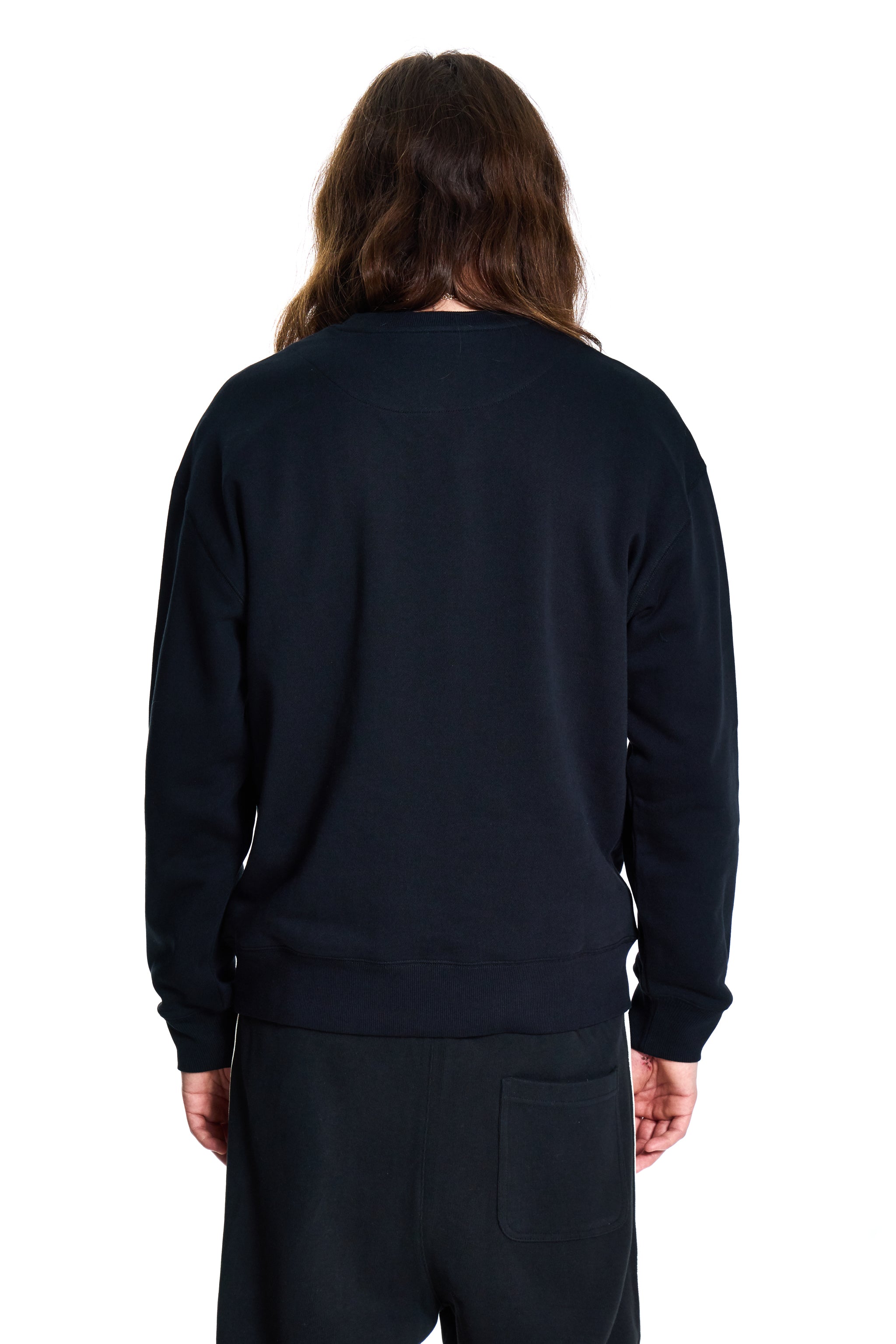 Person wearing a black BOY London sweatshirt and pants on a white background