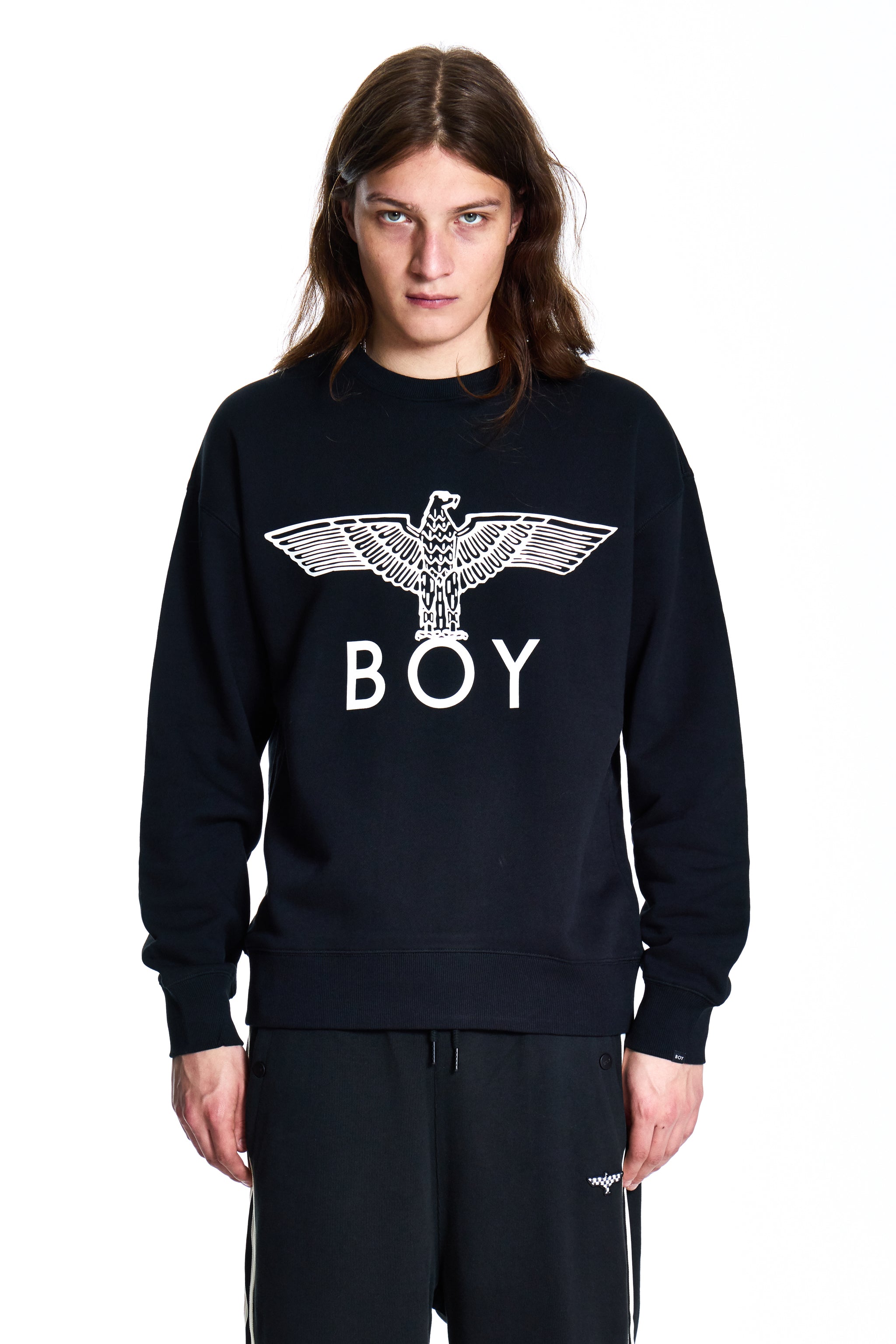 Person wearing a black sweatshirt with 'BOY' and an eagle design on a white background