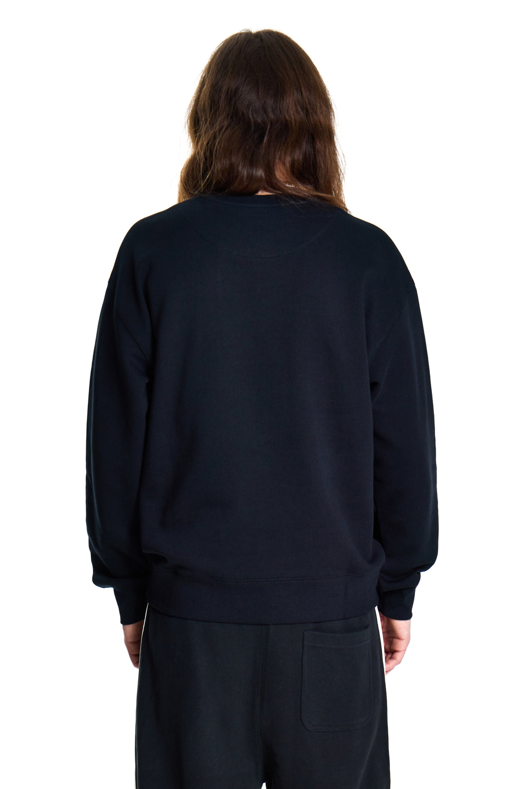 Person wearing a black BOY London sweatshirt and pants on a white background
