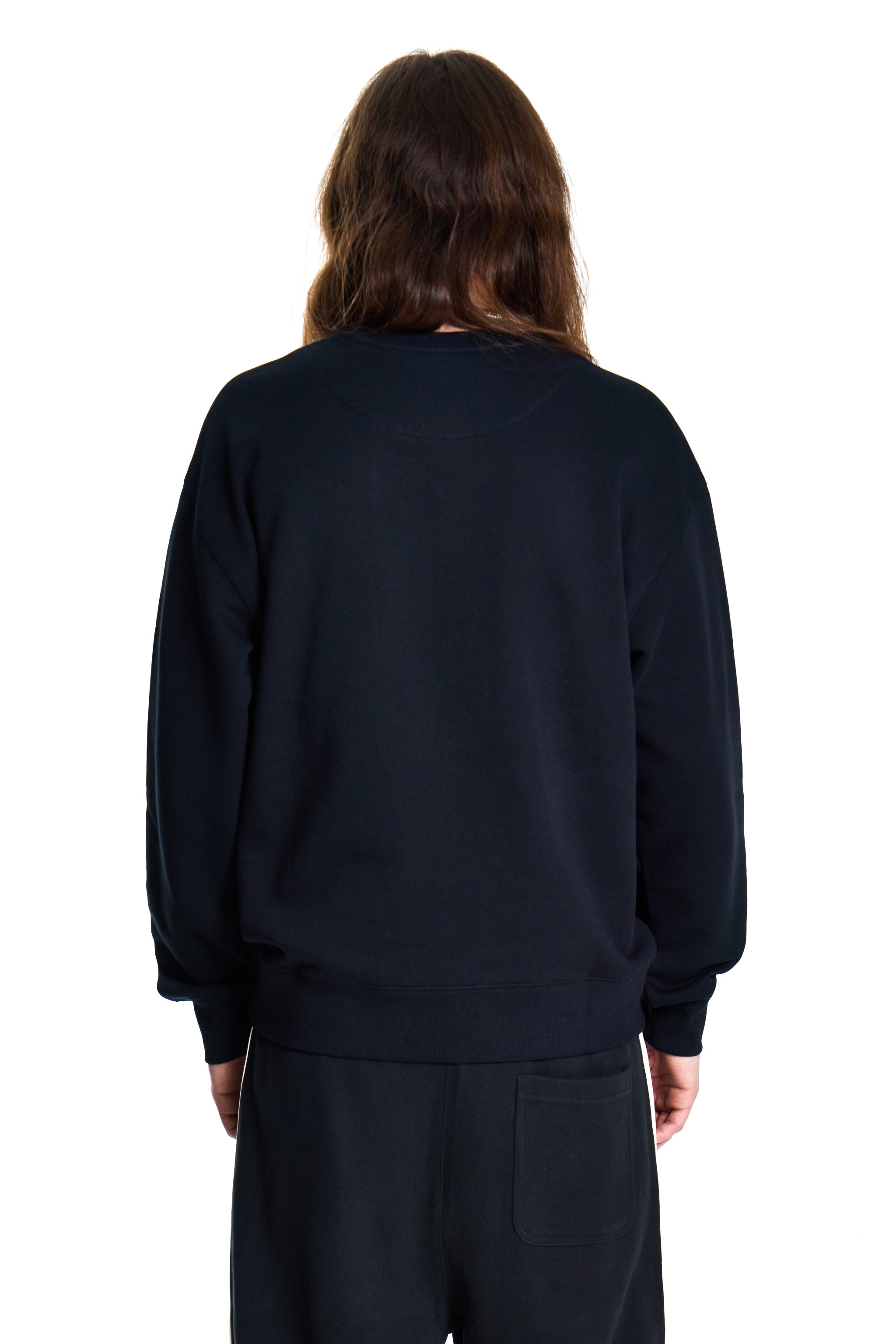 Person wearing a black sweatshirt and pants on a white background
