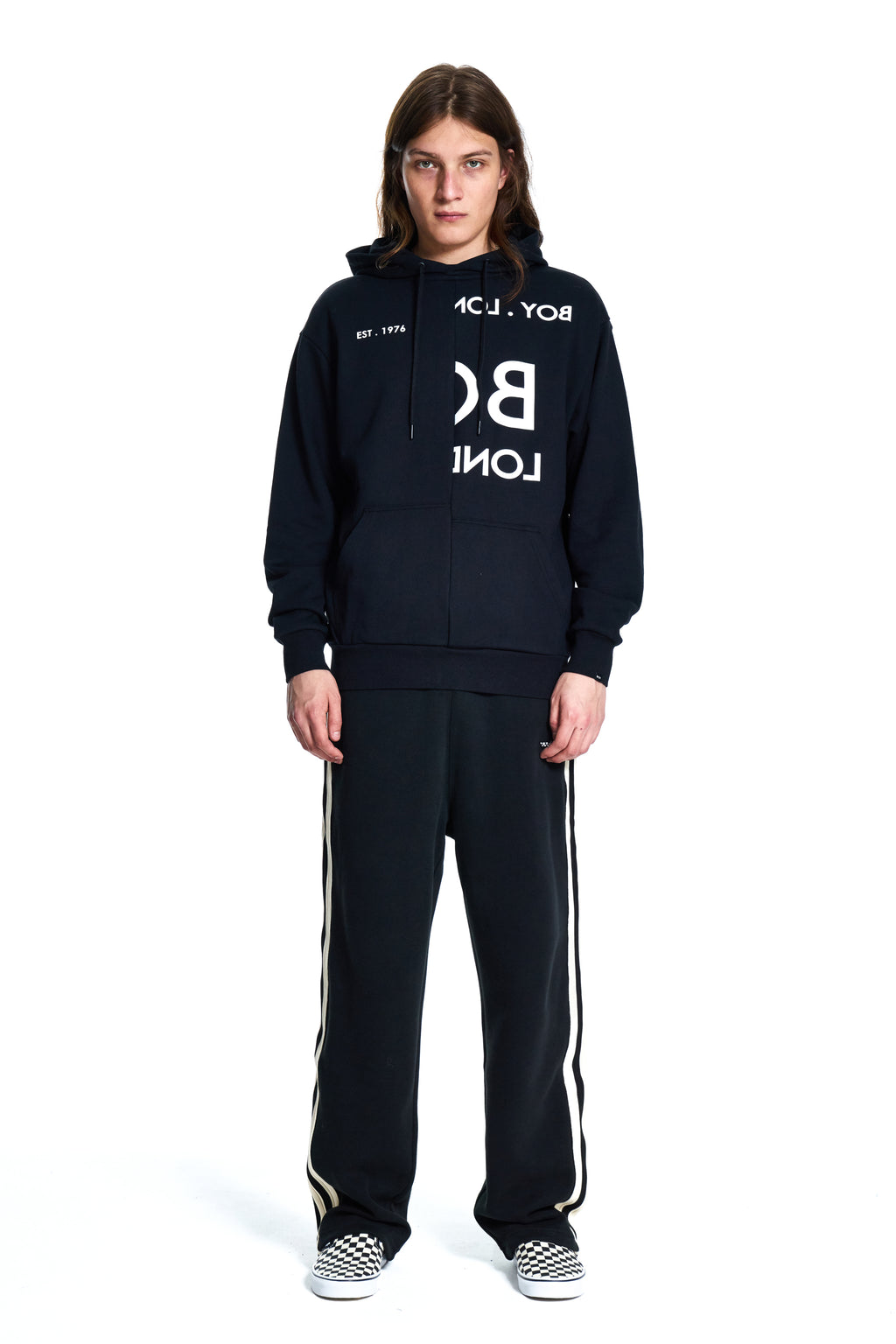 Person wearing a black tracksuit with white text on a white background