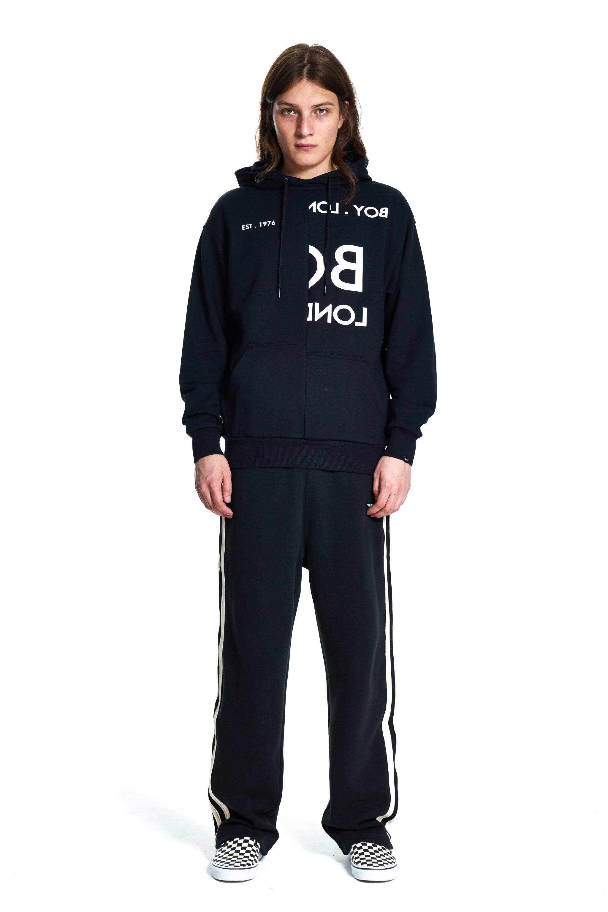 Person wearing a black tracksuit with white text on a white background