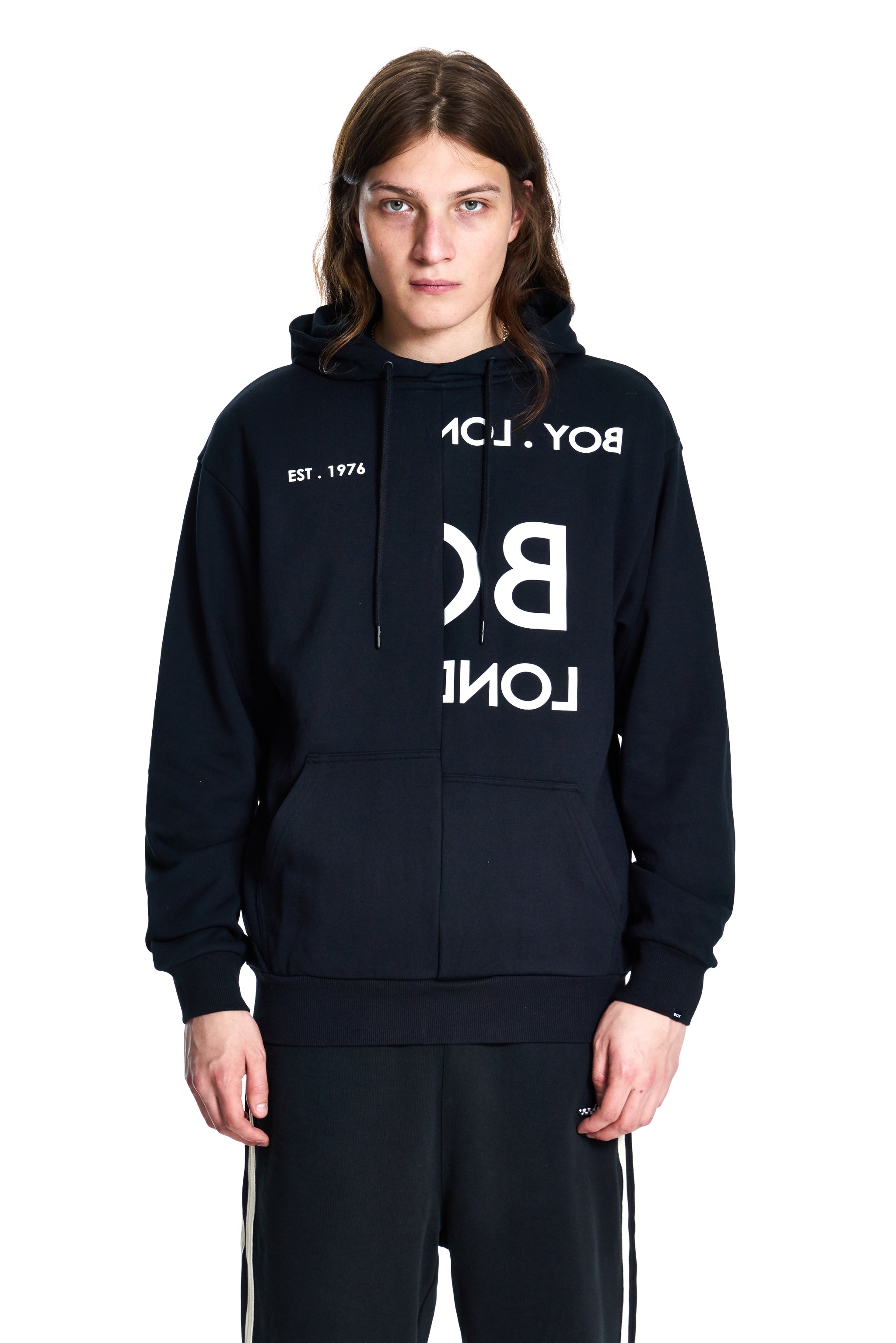 Person wearing a black hoodie with white text on a white background