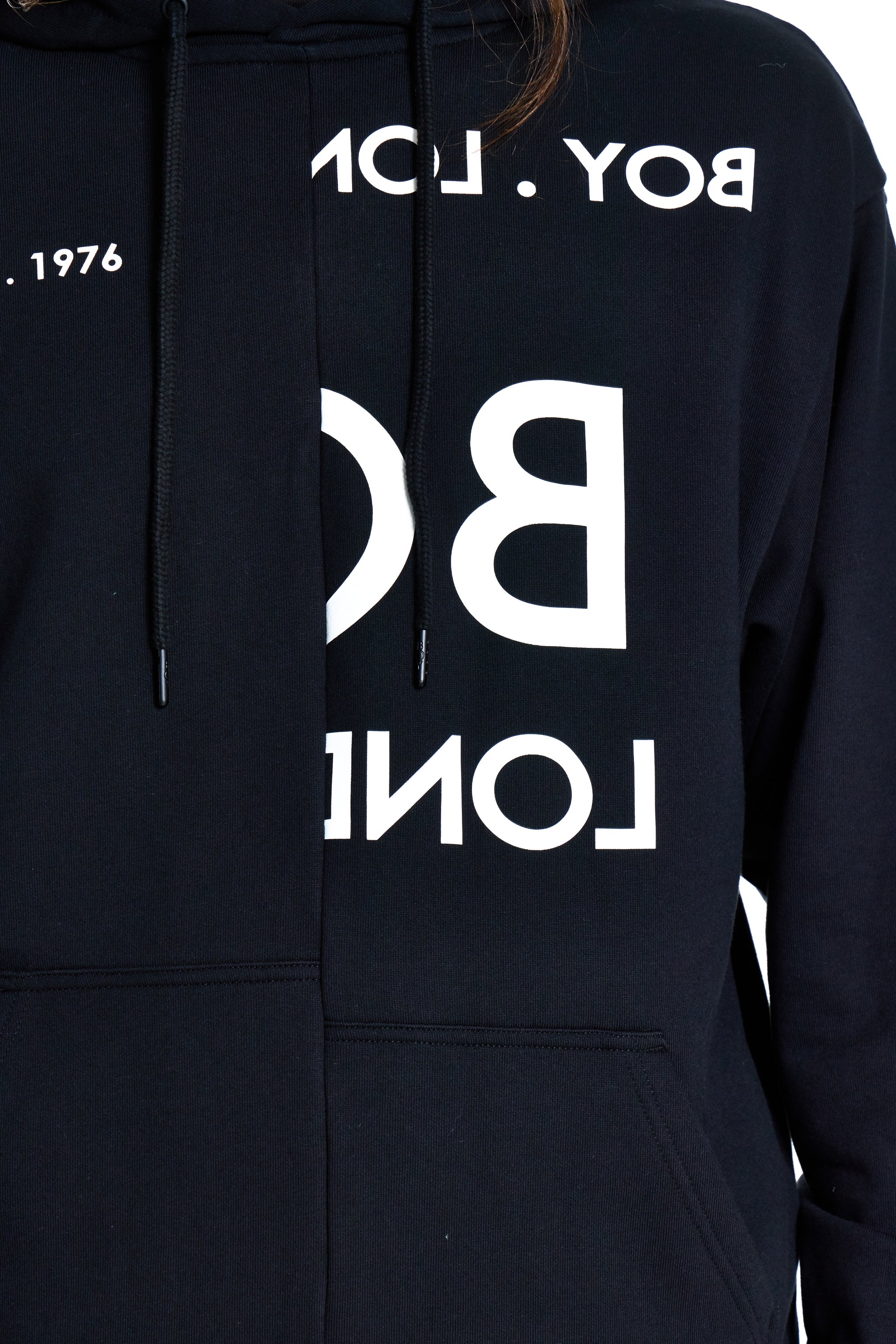 Black hoodie with white branding on a plain background
