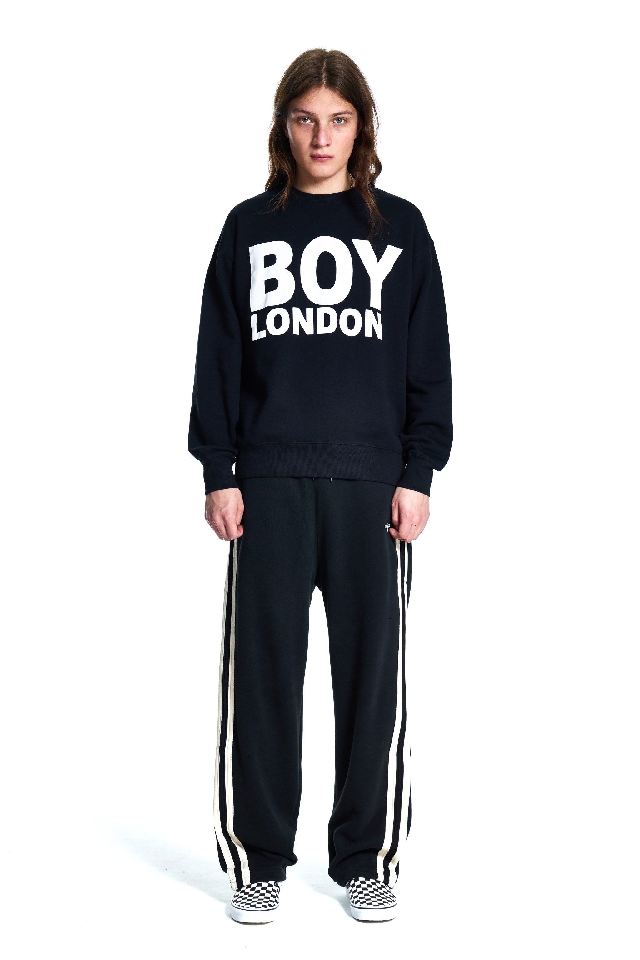 Person wearing a black 'BOY London' sweatshirt and pants on a white background