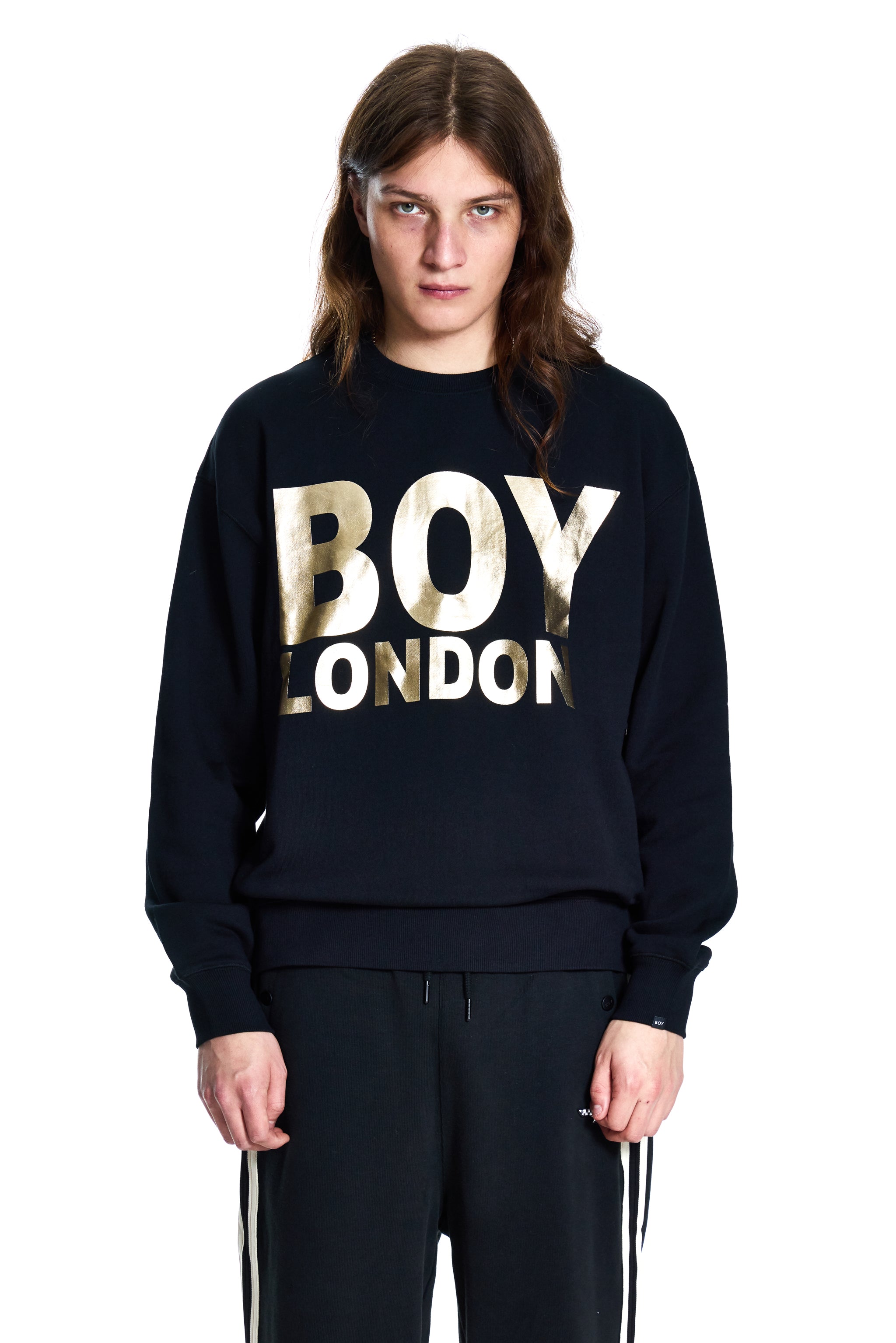 Person wearing a black 'BOY LONDON' sweatshirt on a white background