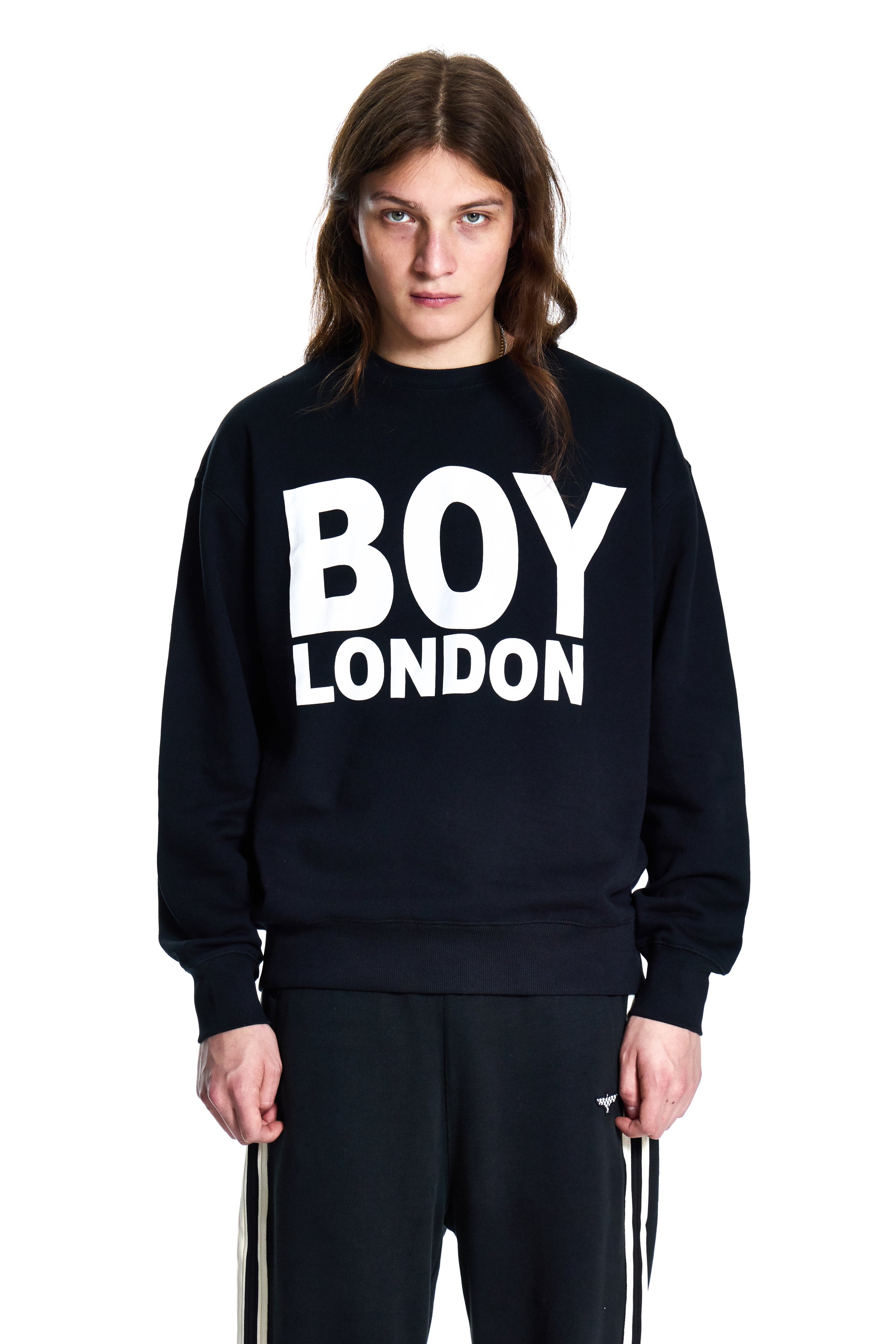 Person wearing a black 'BOY LONDON' sweatshirt on a white background