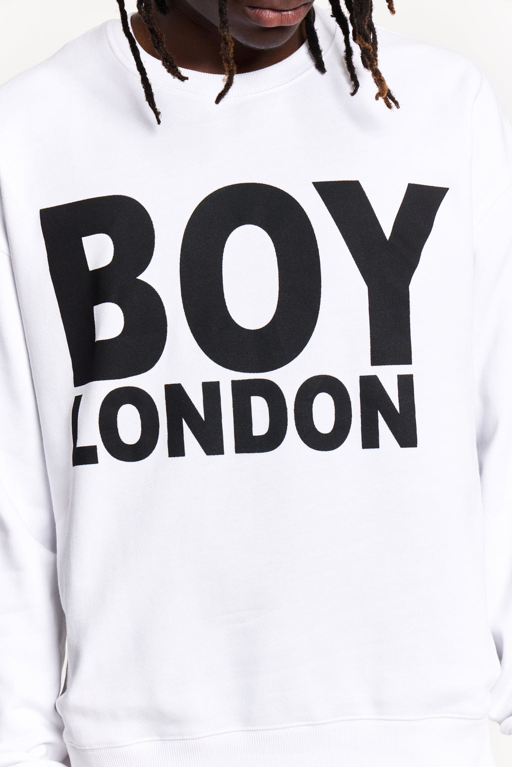 Model wearing White sweatshirt with 'BOY LONDON' text worn by a person