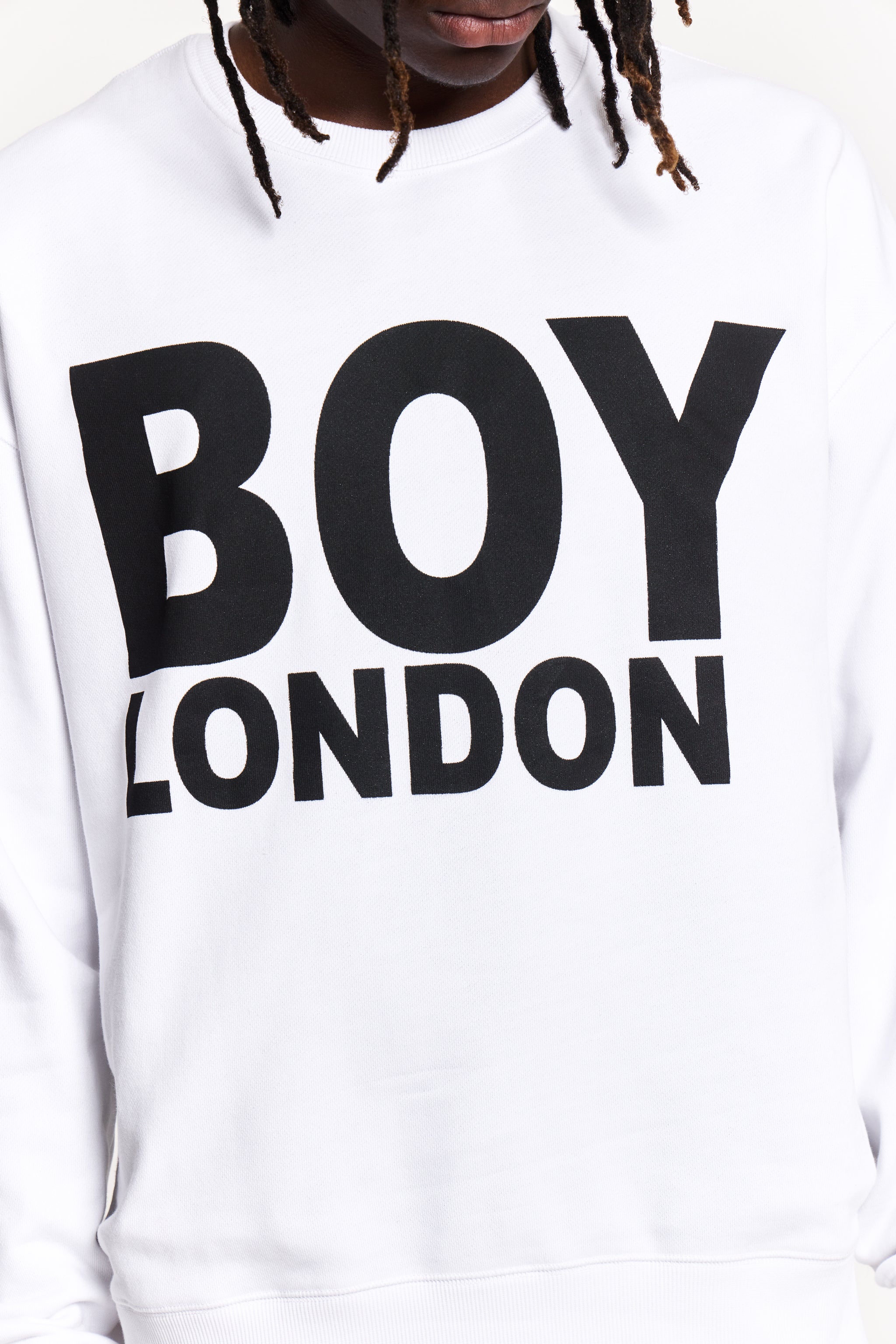 Model wearing White sweatshirt with 'BOY LONDON' text worn by a person