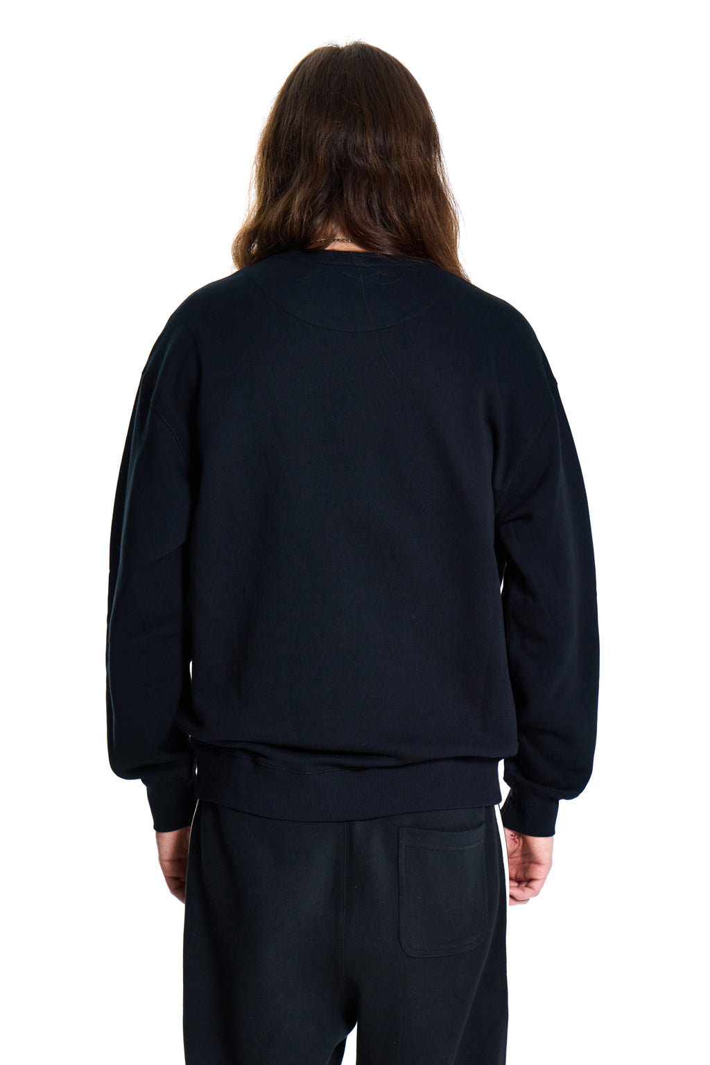 Person wearing a black BOY London sweatshirt and pants on a white background