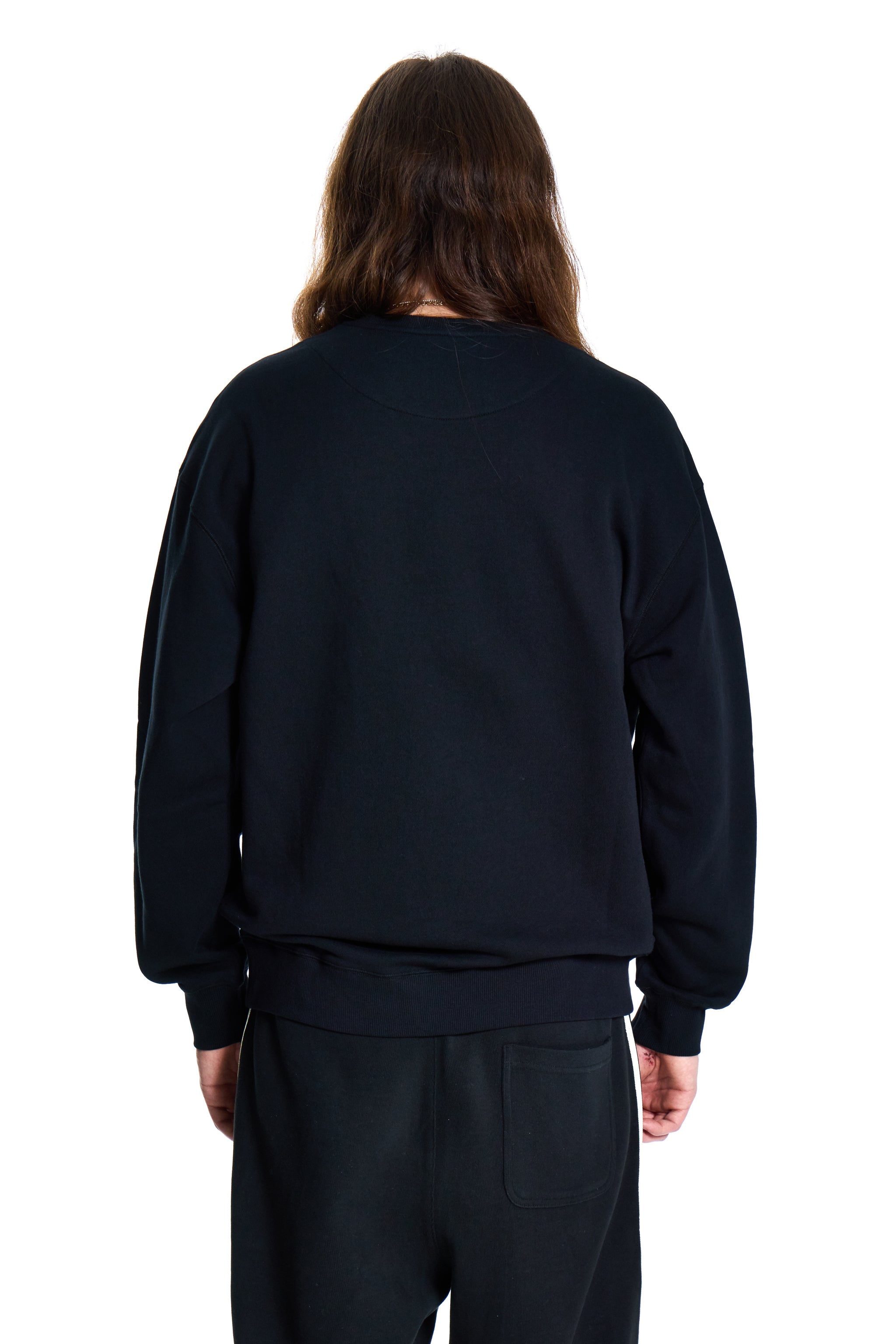 Person wearing a black sweatshirt and pants on a white background