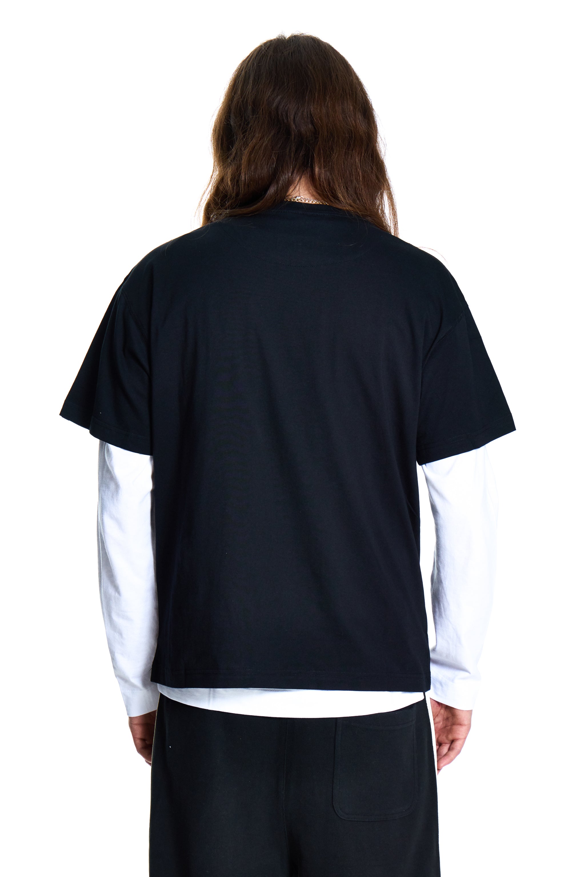 Person wearing a black and white shirt with long hair on a white background