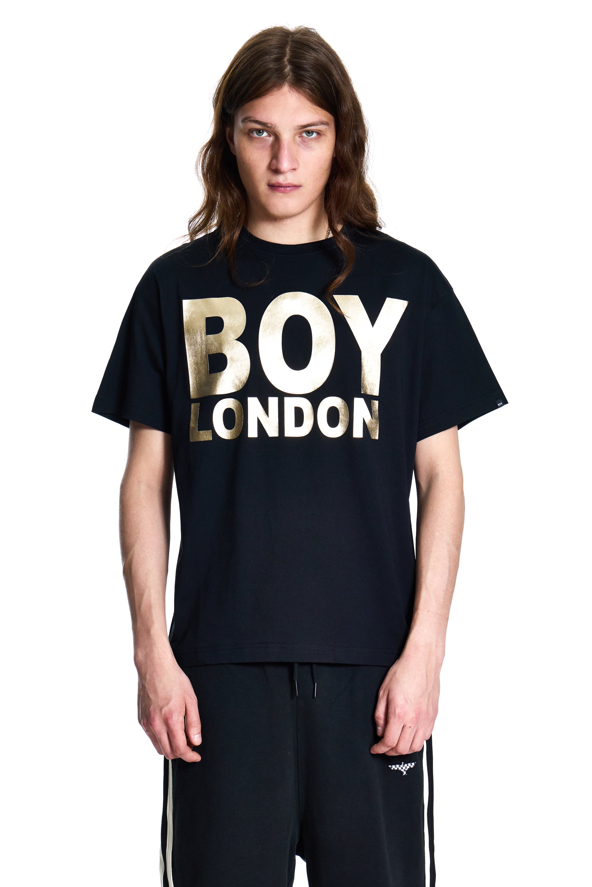 Person wearing a black 'BOY LONDON' t-shirt on a white background