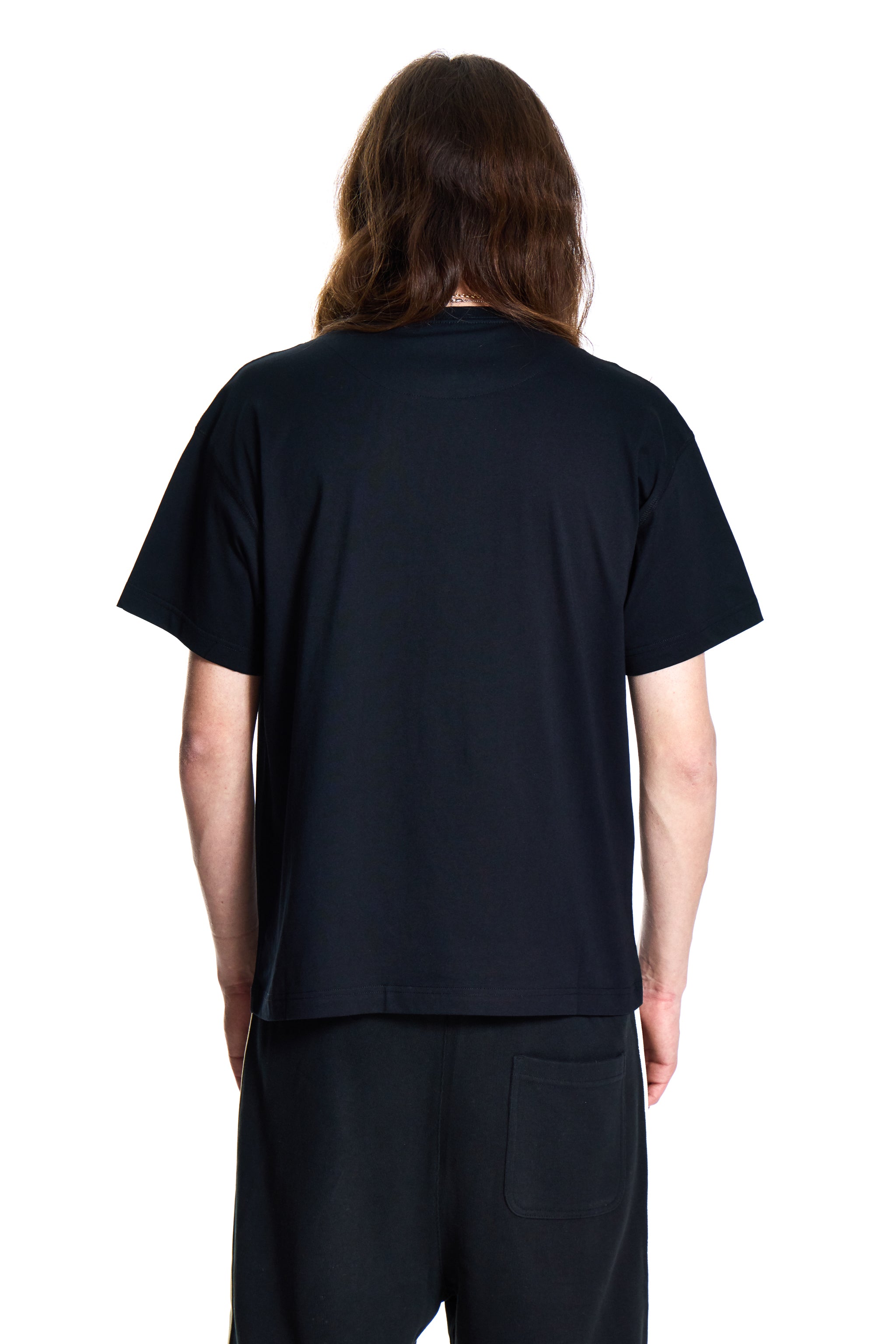 Person wearing a black t-shirt and pants on a white background