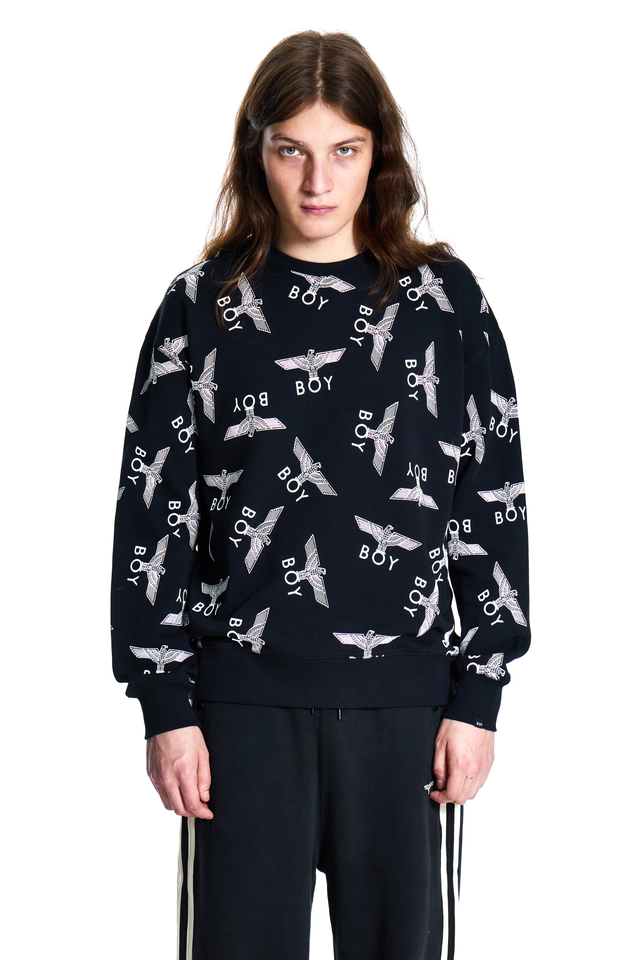 Person wearing a Boy London black sweater with white patterns on a white background