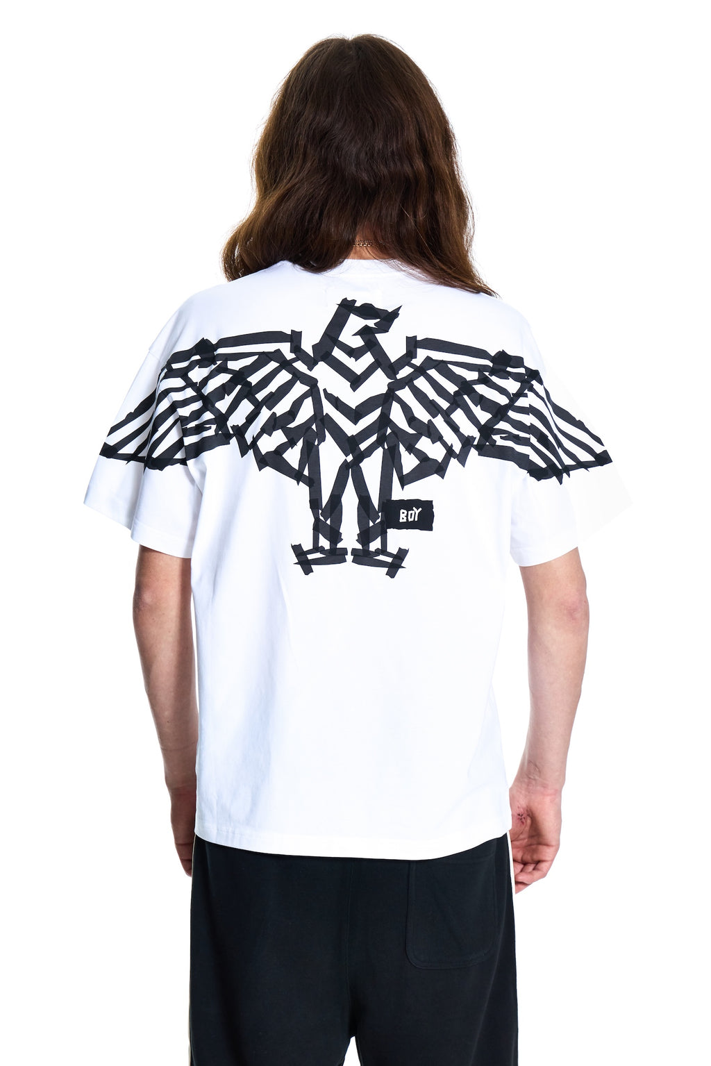 Person wearing a white t-shirt with a black eagle design on the back, standing against a white background.