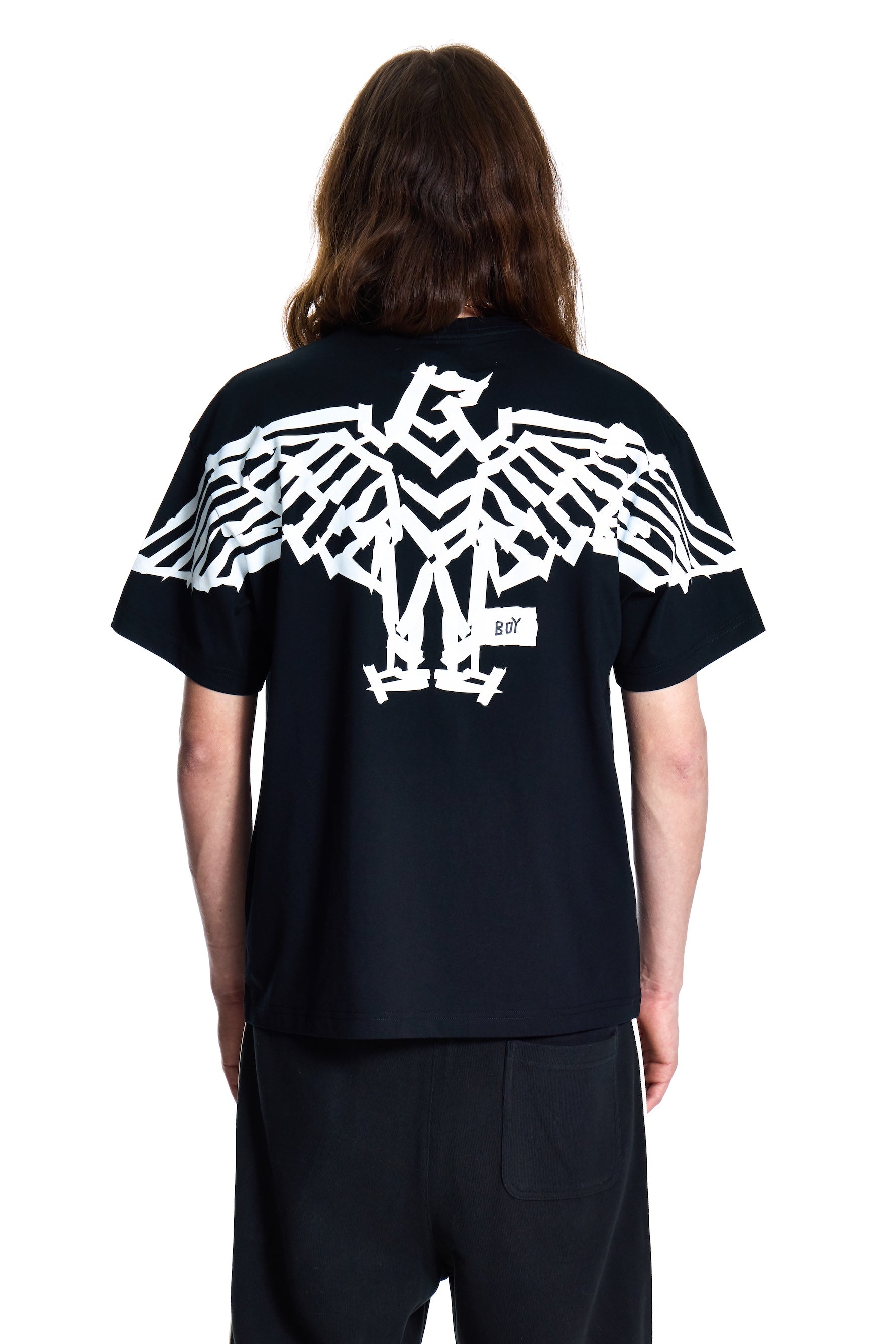 Person wearing a black t-shirt with a white eagle design on the back, standing against a white background.