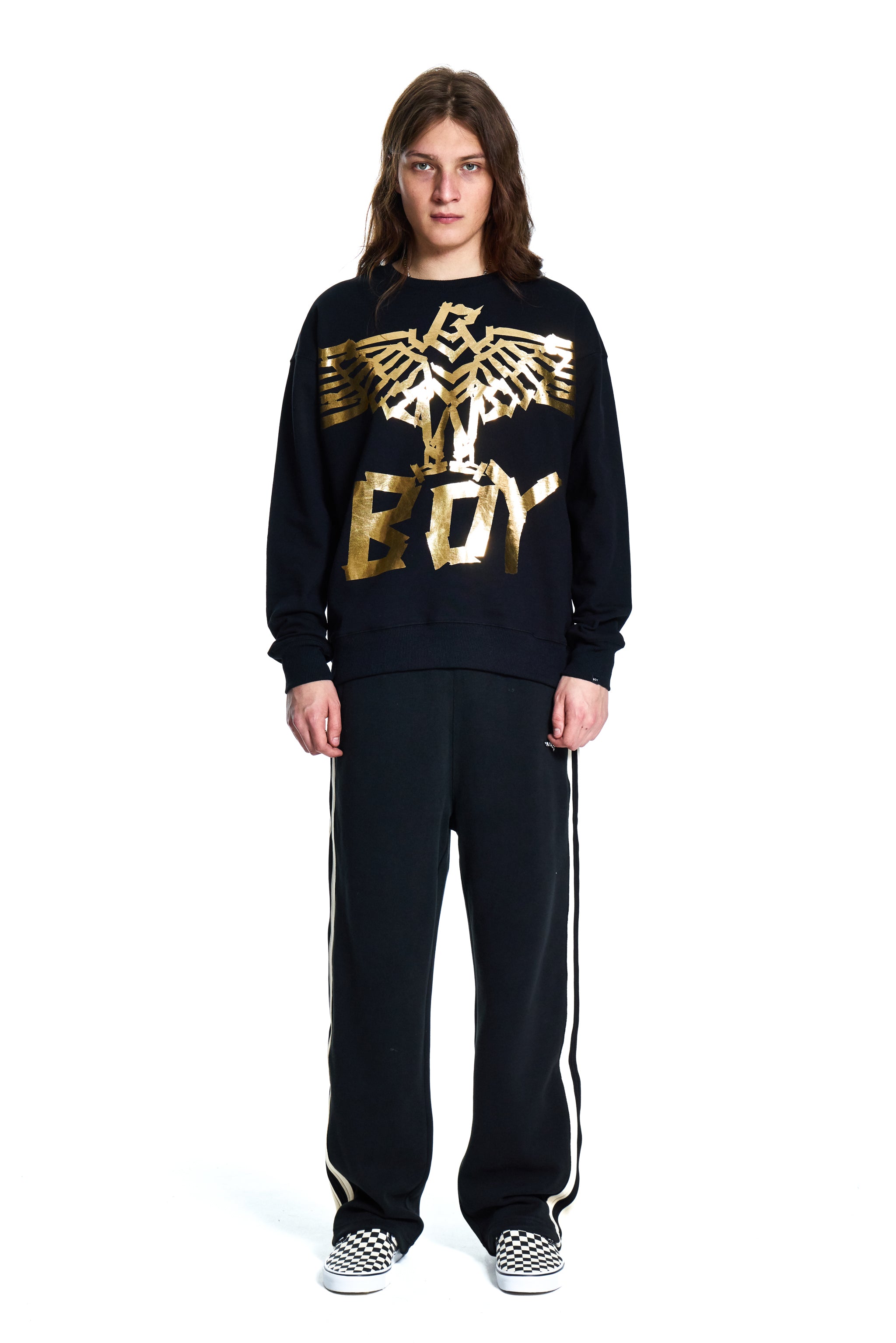 Person wearing a black Boy London  tracksuit with gold logo on a white background