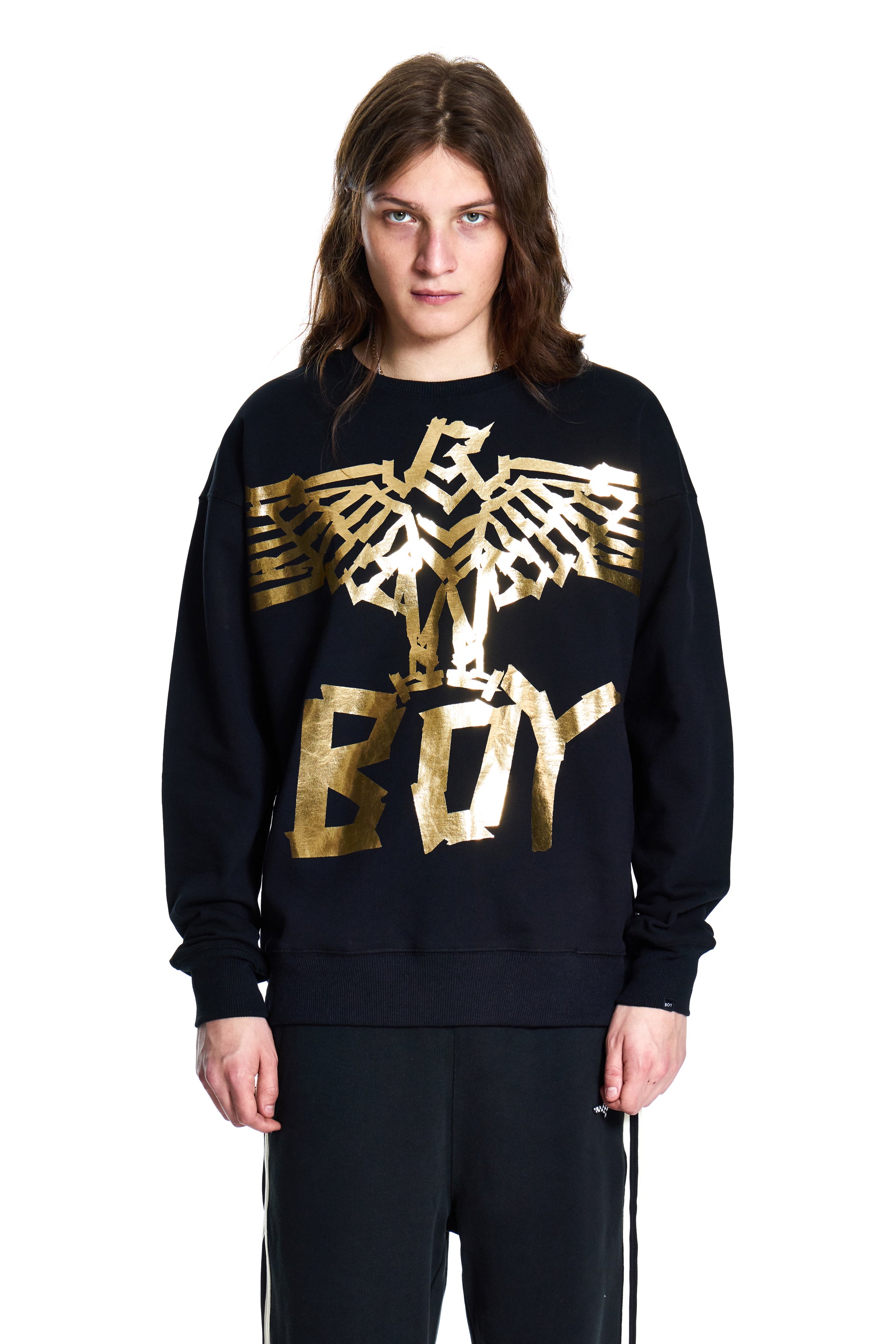 Person wearing a black Boy London sweatshirt with gold 'BOY' logo on a white background