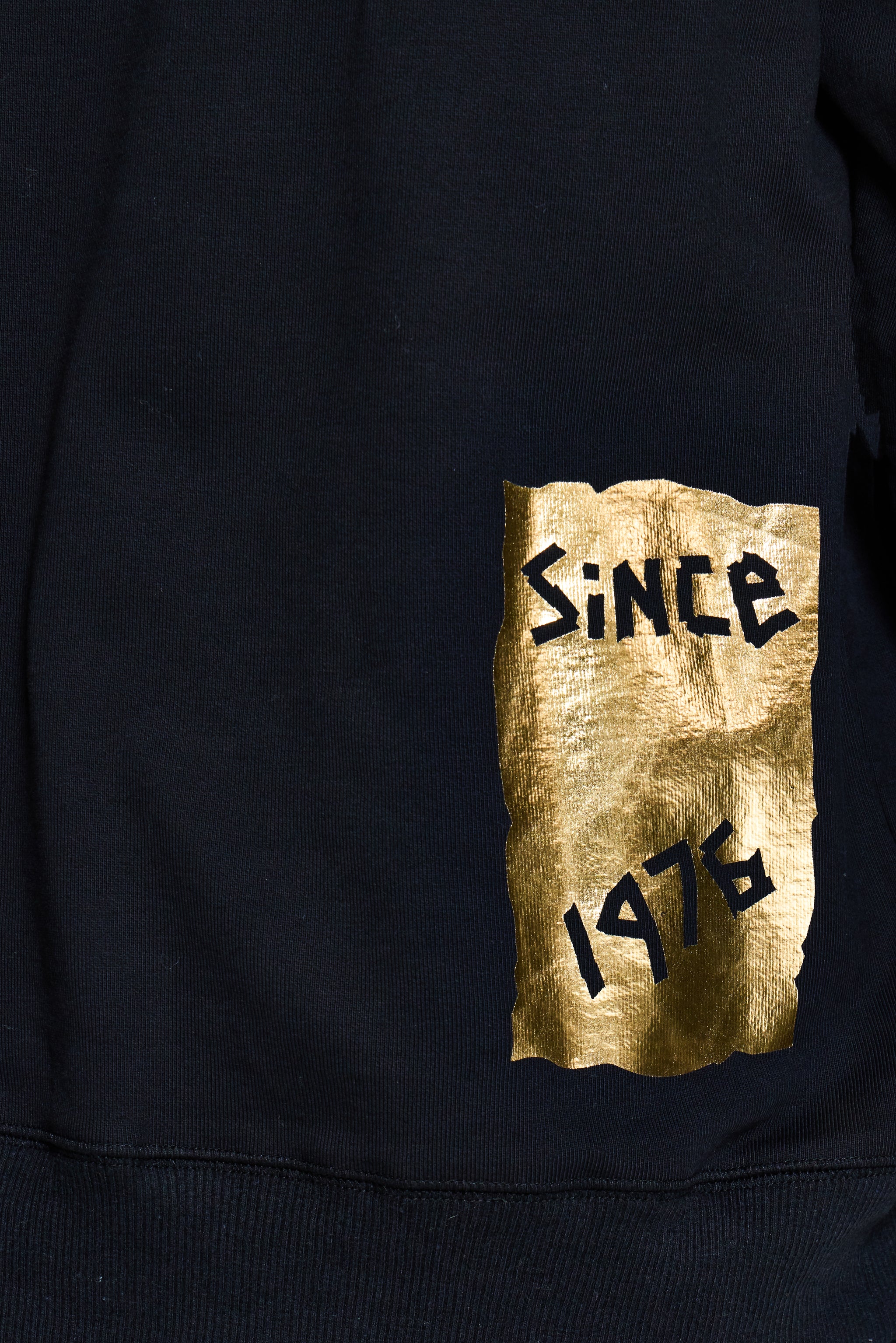 Black sweatshirt with gold and black text 'SINCE 1476' on a pocket
