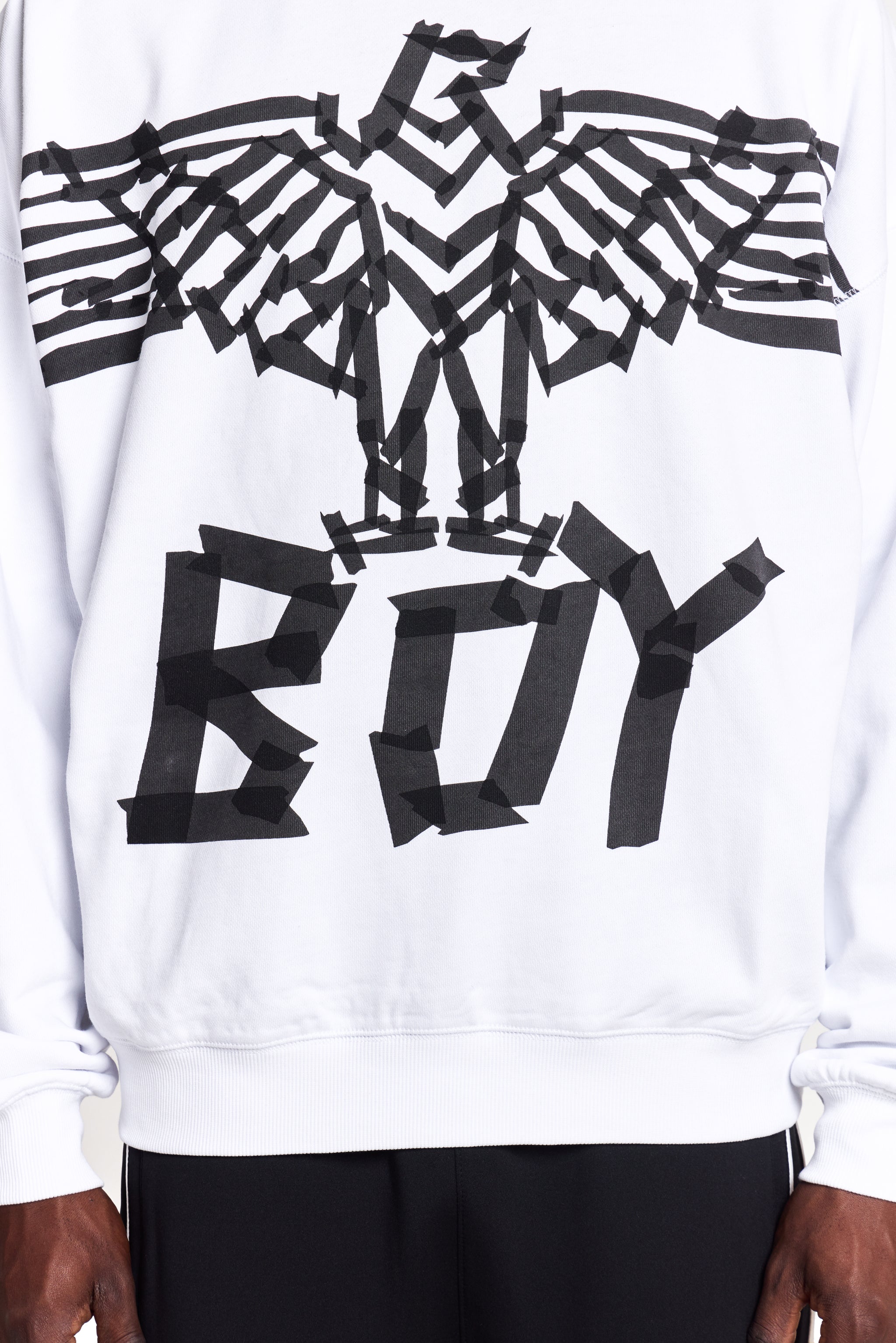 Model wearing White BOY London sweatshirt with black abstract design and 'BOY' text on a white background