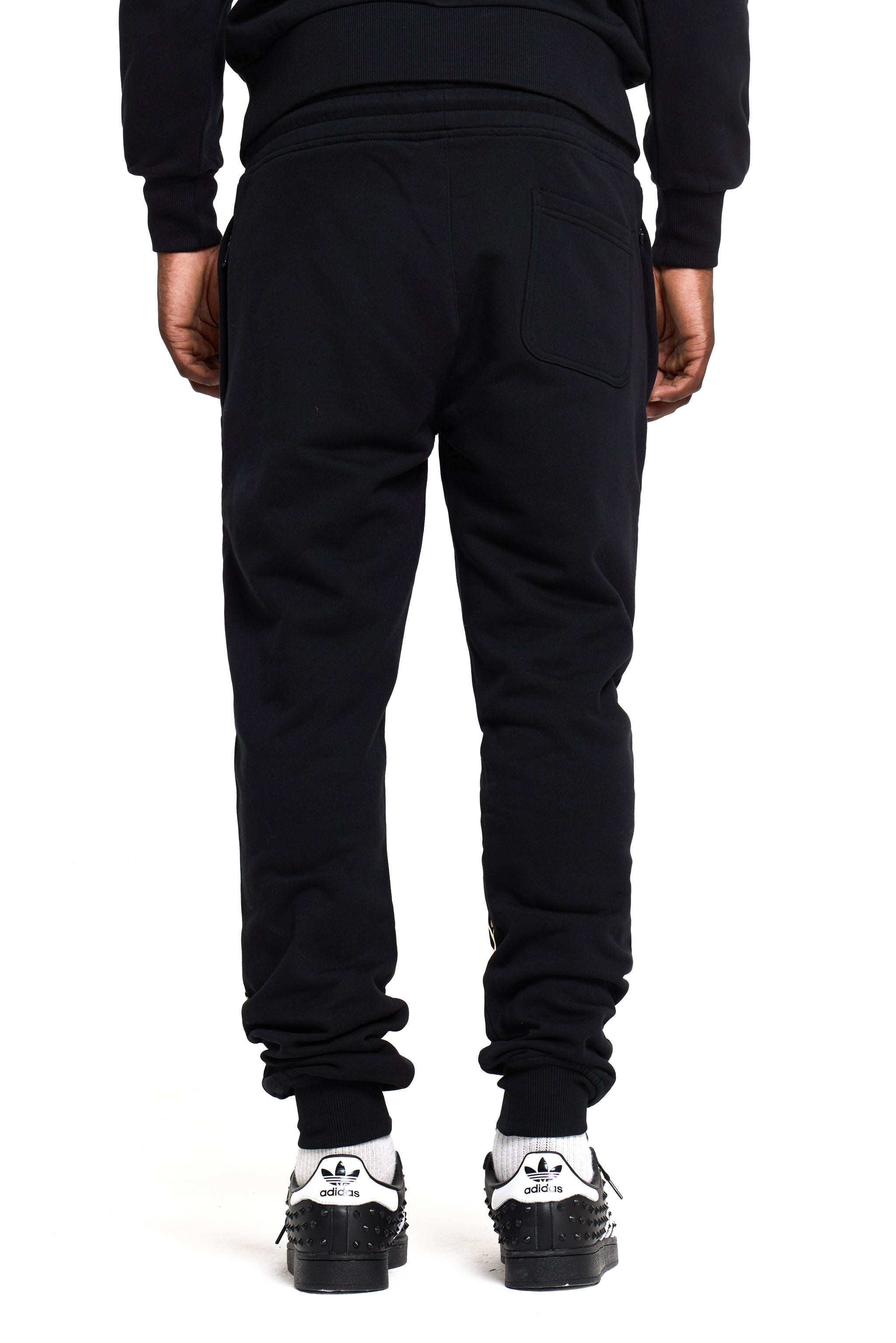 Person wearing black BOY London sweatpants on a white background
