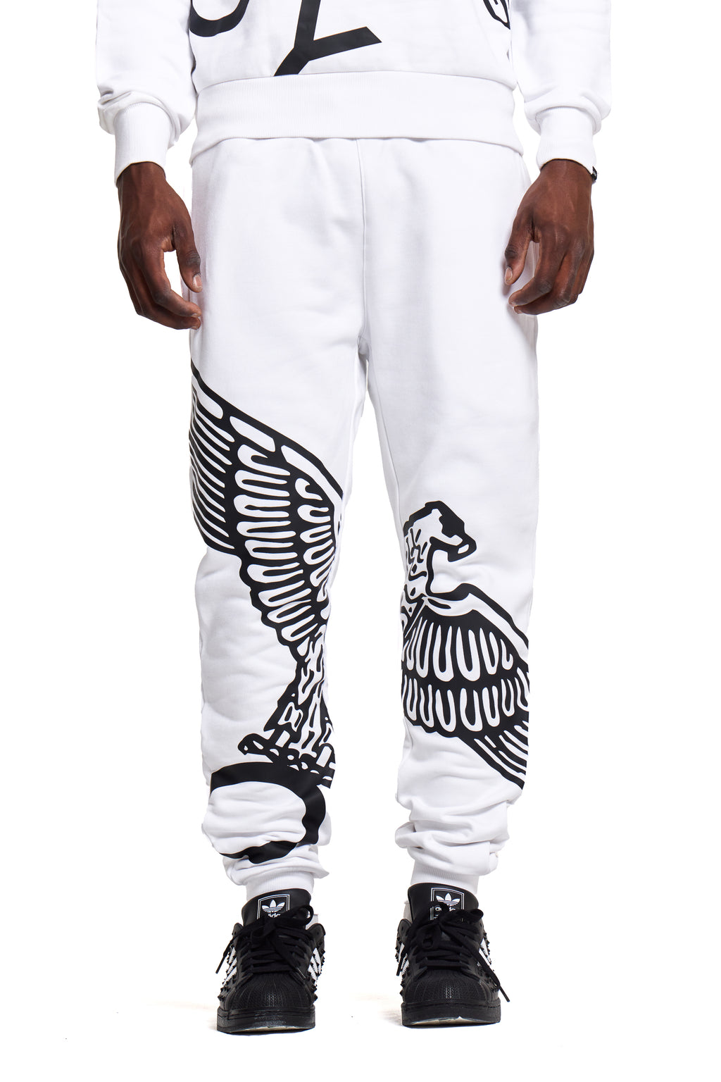 White BOY London jogger pants with black eagle design worn by a person on a white background