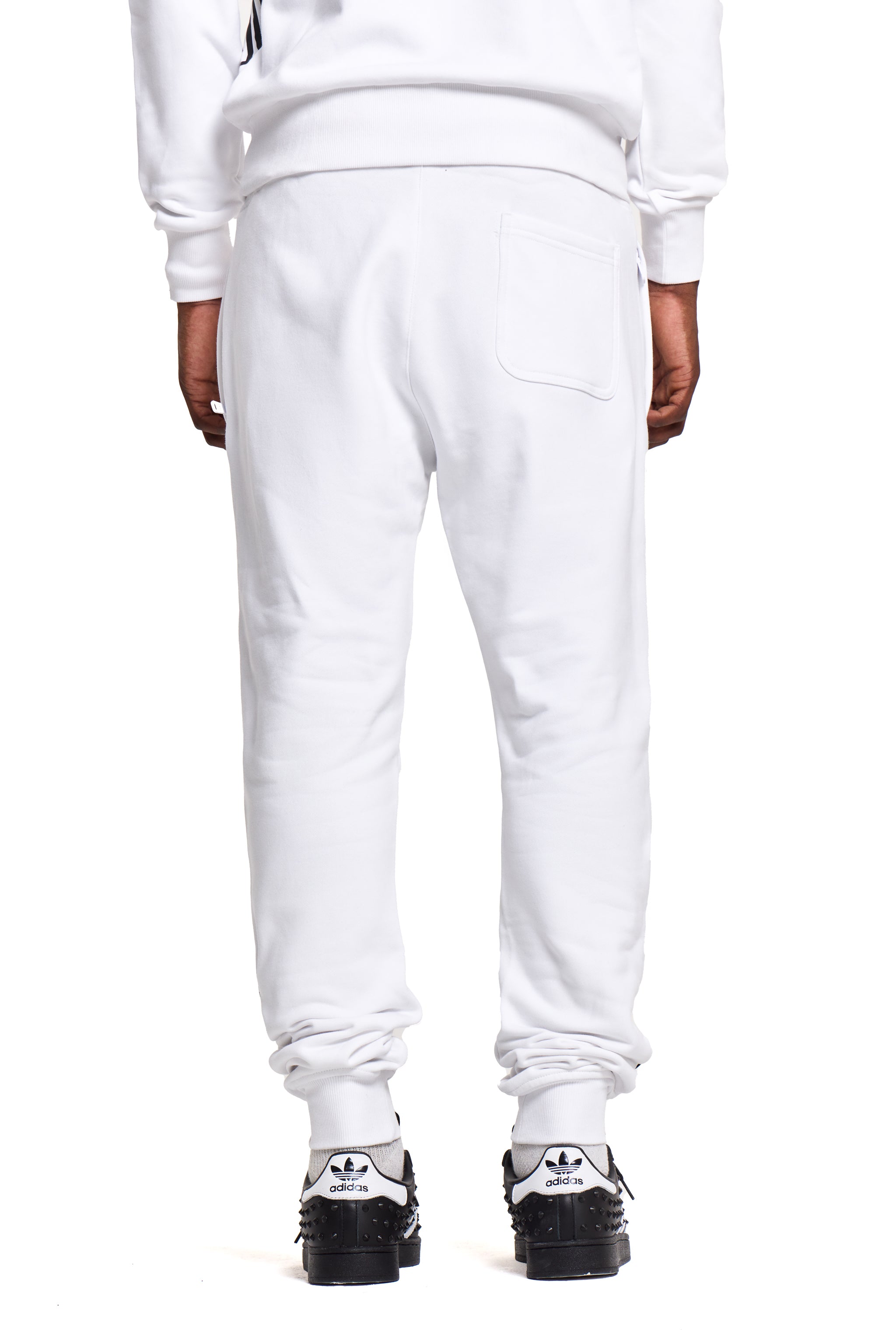 White BOY London sweatpants worn by a person on a white background