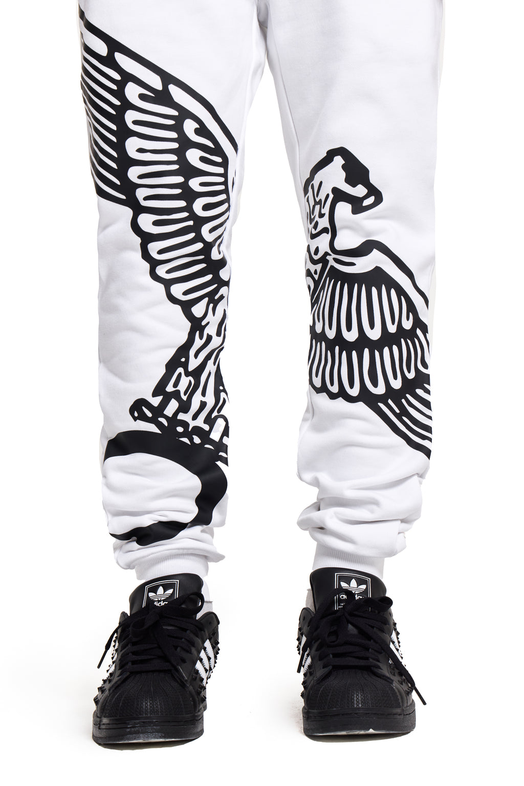 White BOY London sweatpants with black eagle design worn with black sneakers on a white background