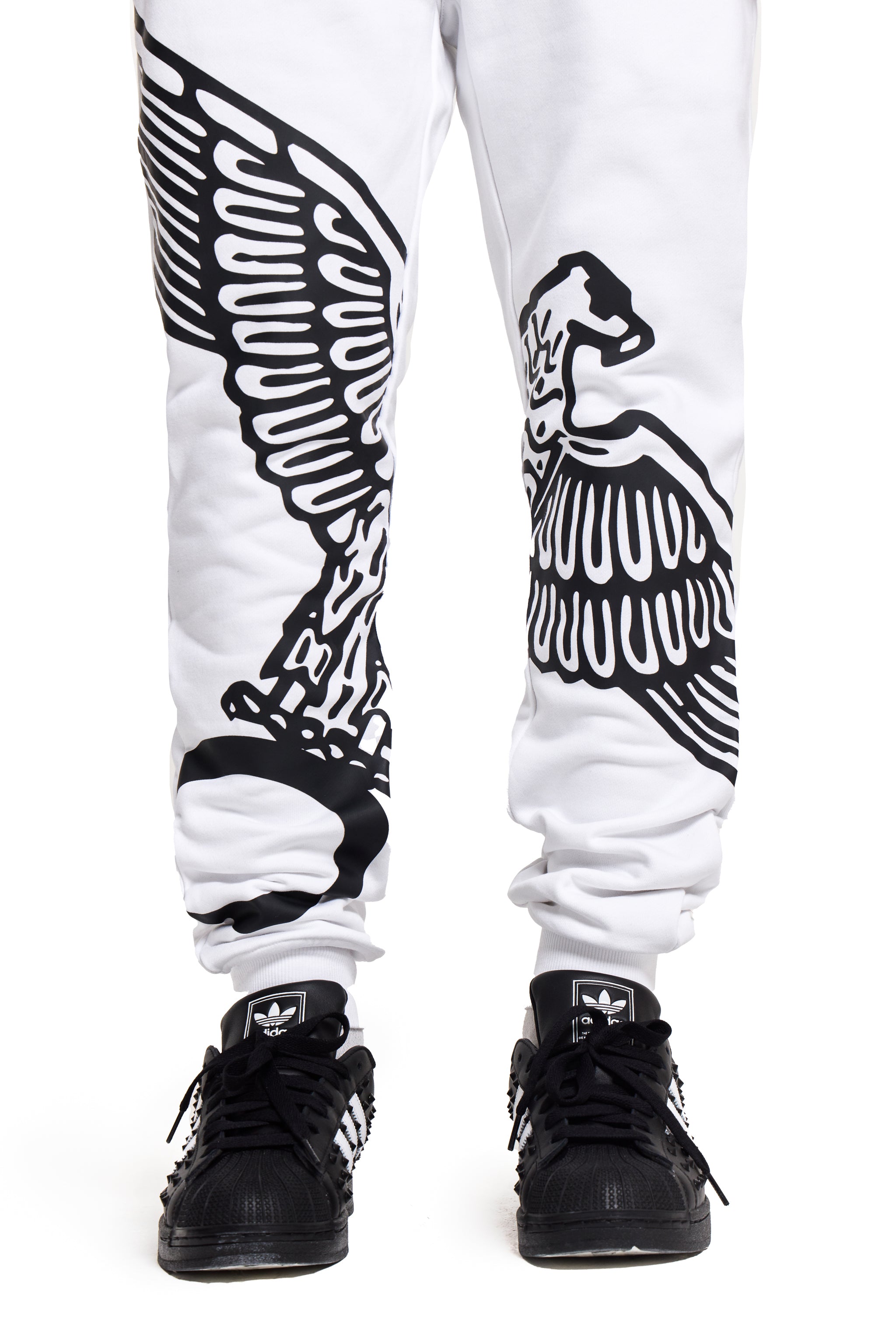 White BOY London sweatpants with black eagle design worn with black sneakers on a white background