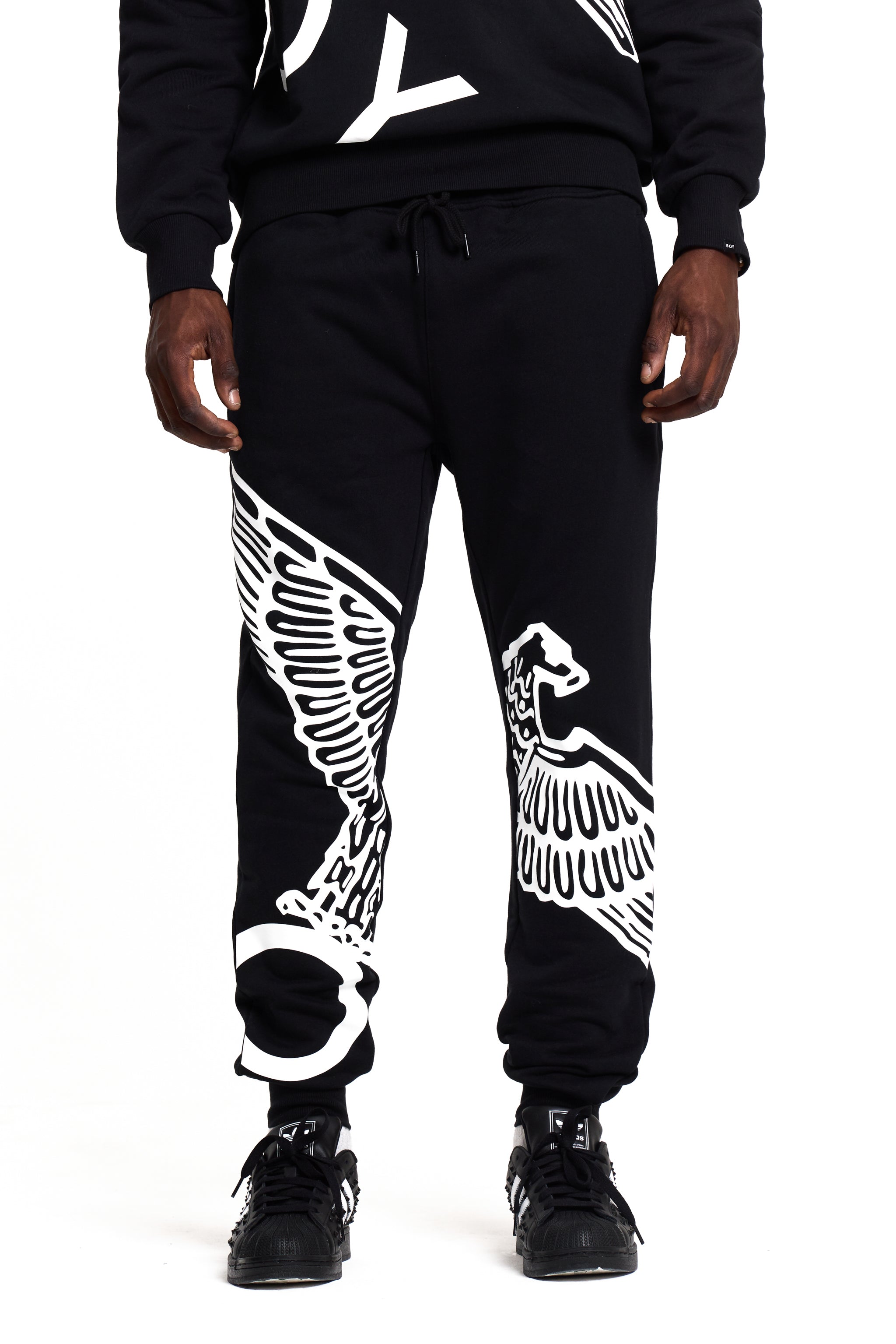 Black BOY London jogger pants with white eagle designs on a white background