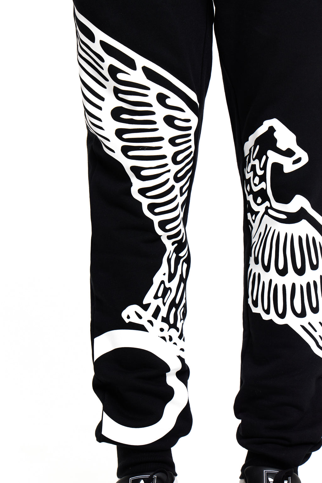 Black BOY London pants with white wing-like designs on a white background