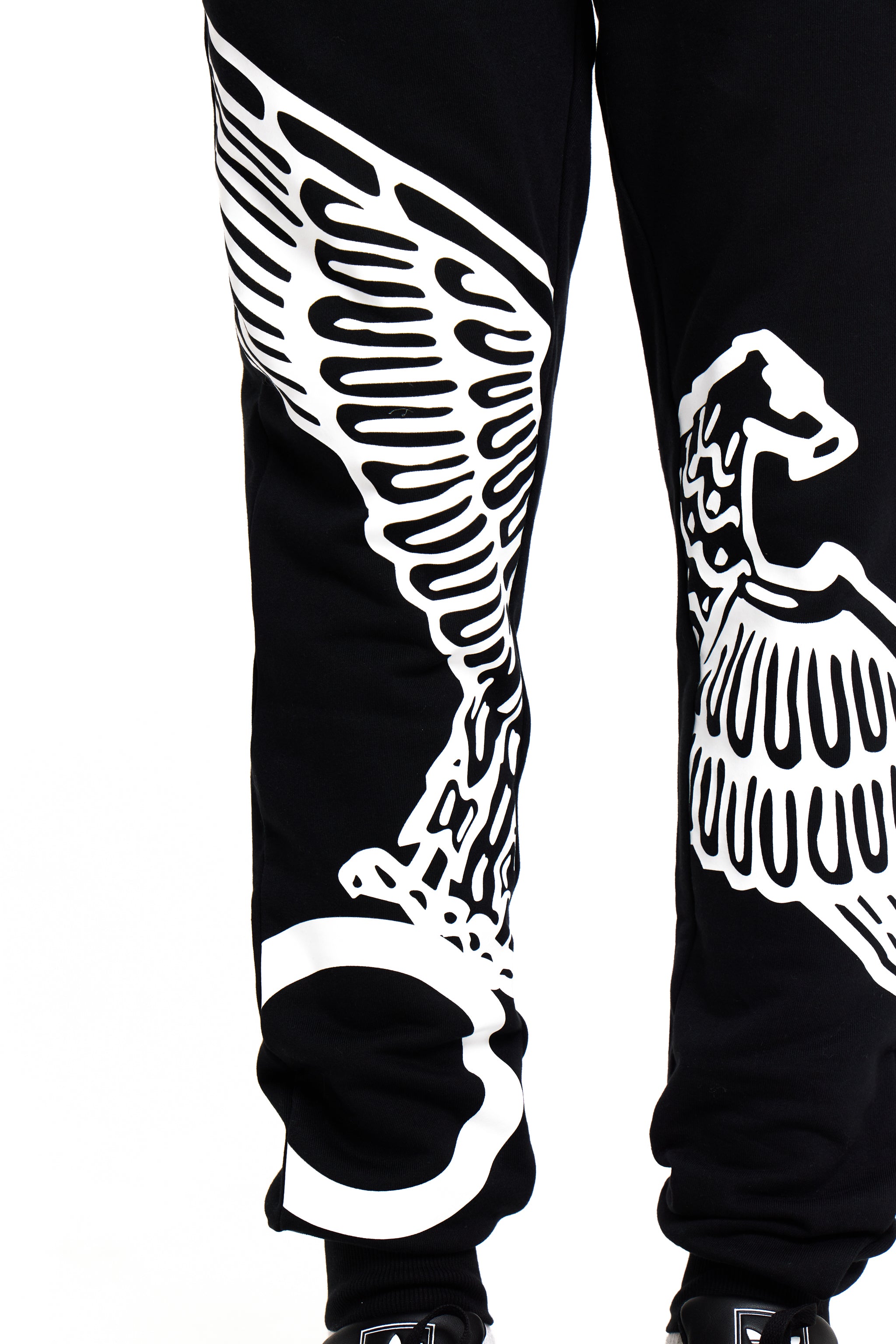 Black BOY London pants with white wing-like designs on a white background