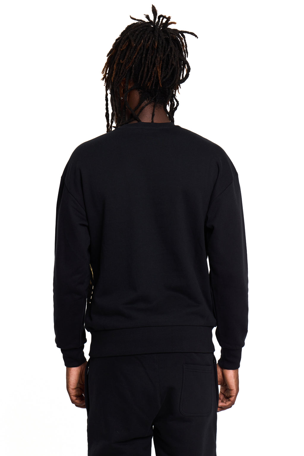 Model wearing a BOY London black sweatshirt and pants on a white background
