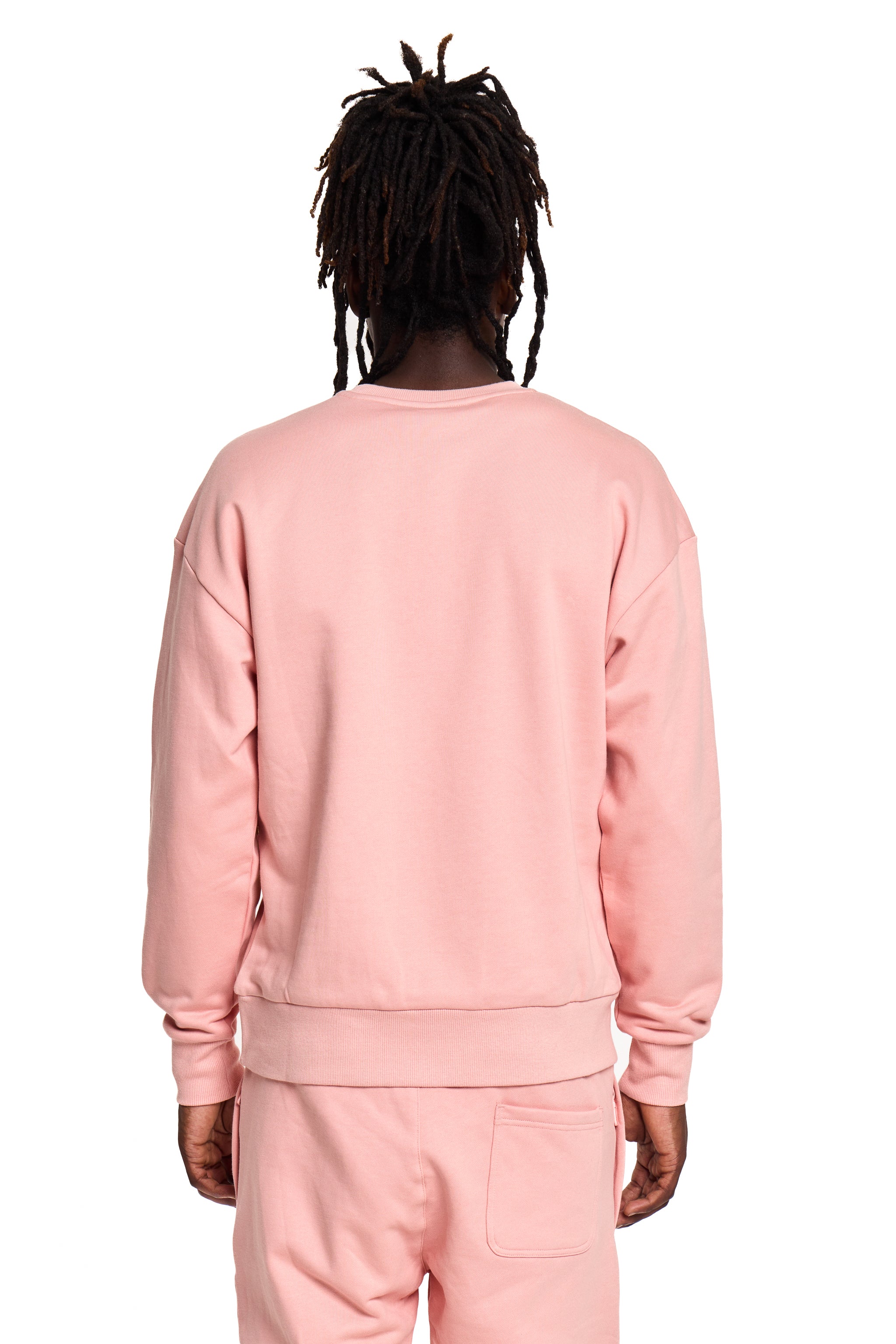 Person wearing a pink BOY London sweatshirt and pants set on a white background