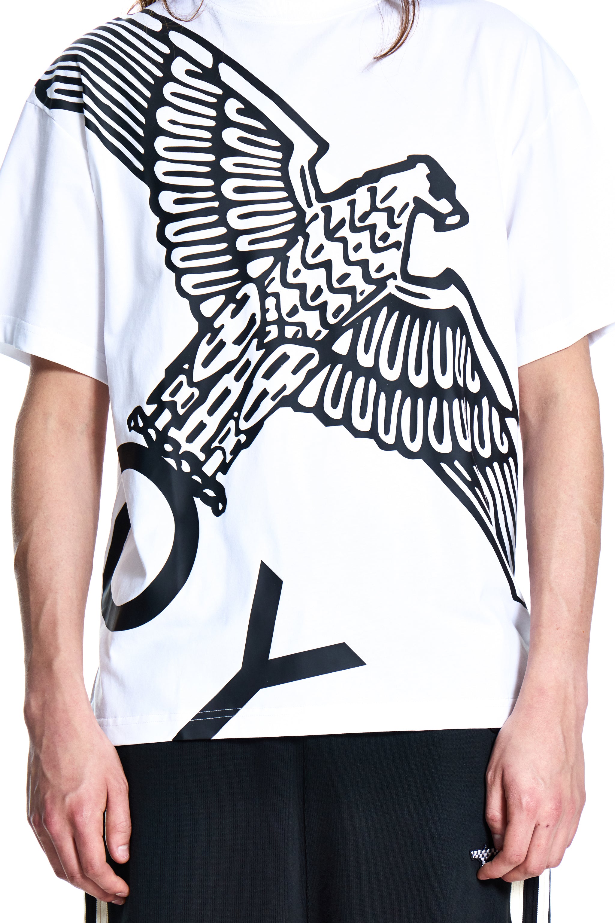 White t-shirt with black eagle design worn by a person