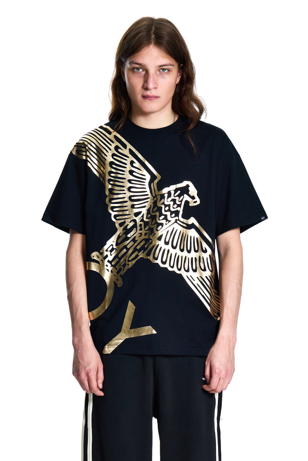 Person wearing a black t-shirt with a gold and white eagle design on a white background