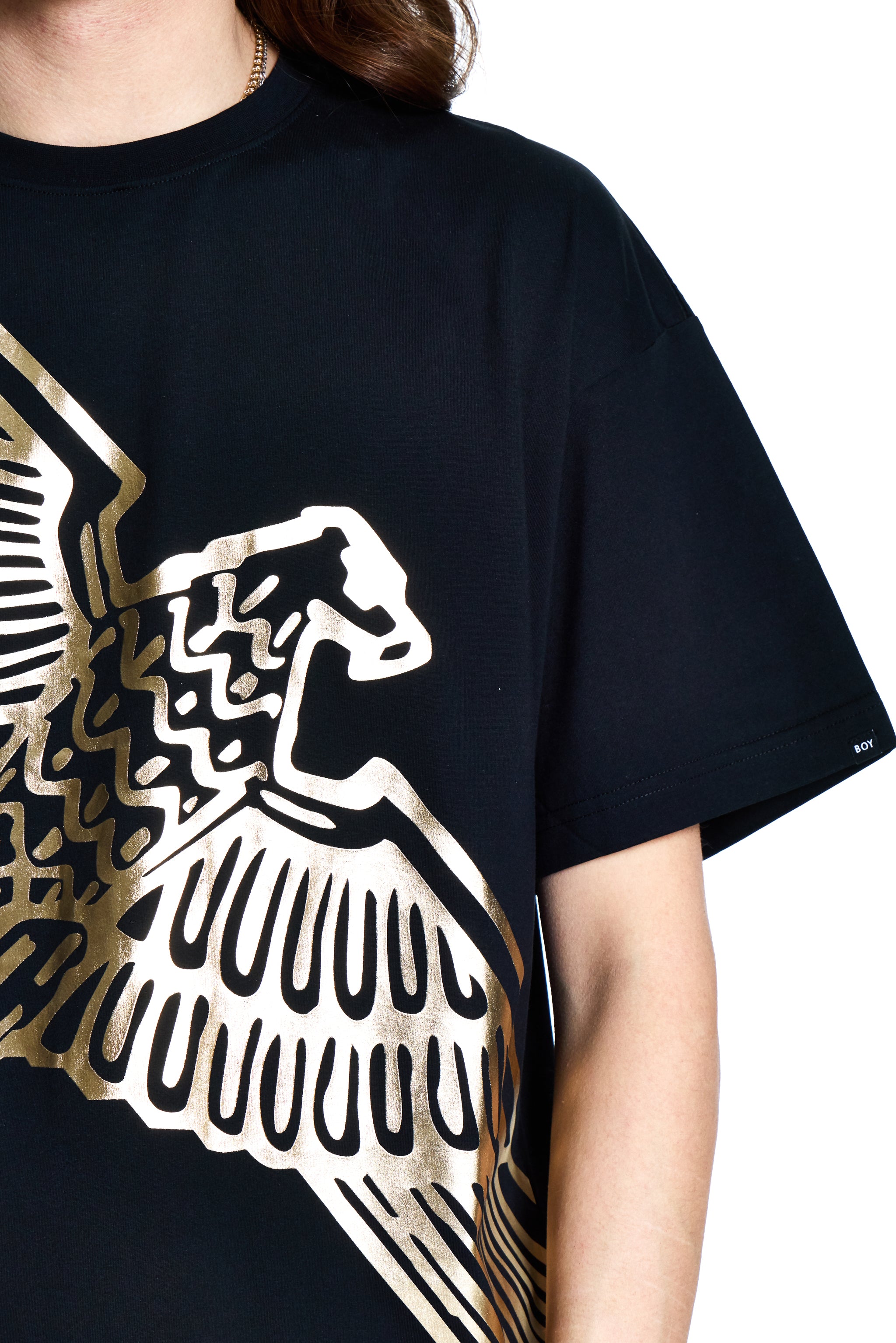 Black t-shirt with gold eagle design worn by a person