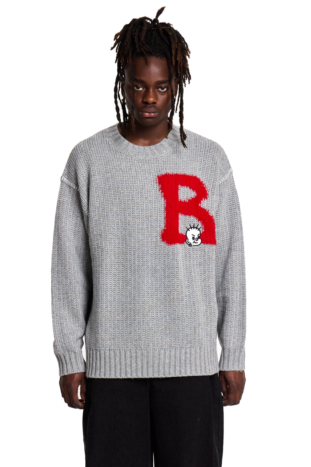 Person wearing a gray Boy London sweater with a red logo on a white background