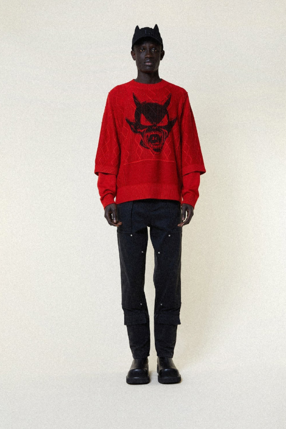 Model wearing a red BOY London sweater with a black graphic design on a white background