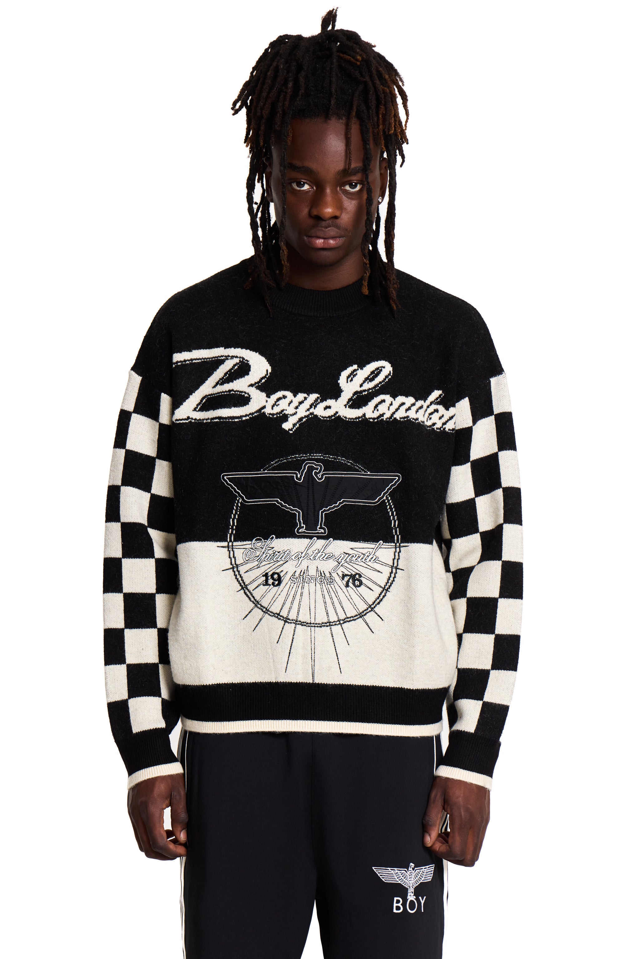 Person wearing a black and white Boy London checkered sweater with 'Boy London' branding on a white background