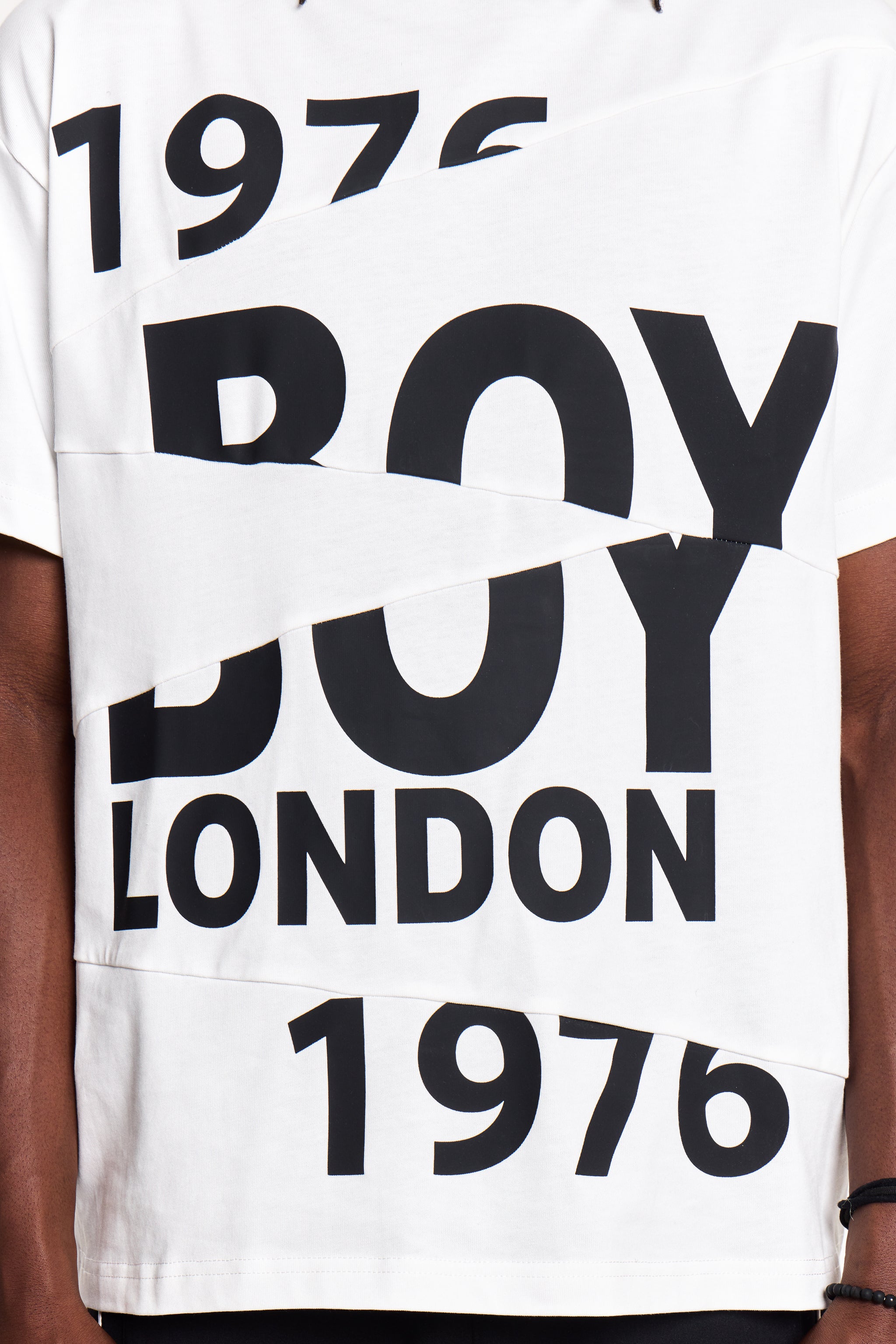 White Boy London t-shirt with black text '1976 BOY LONDON 1976' on a person wearing a black sleeveless shirt.