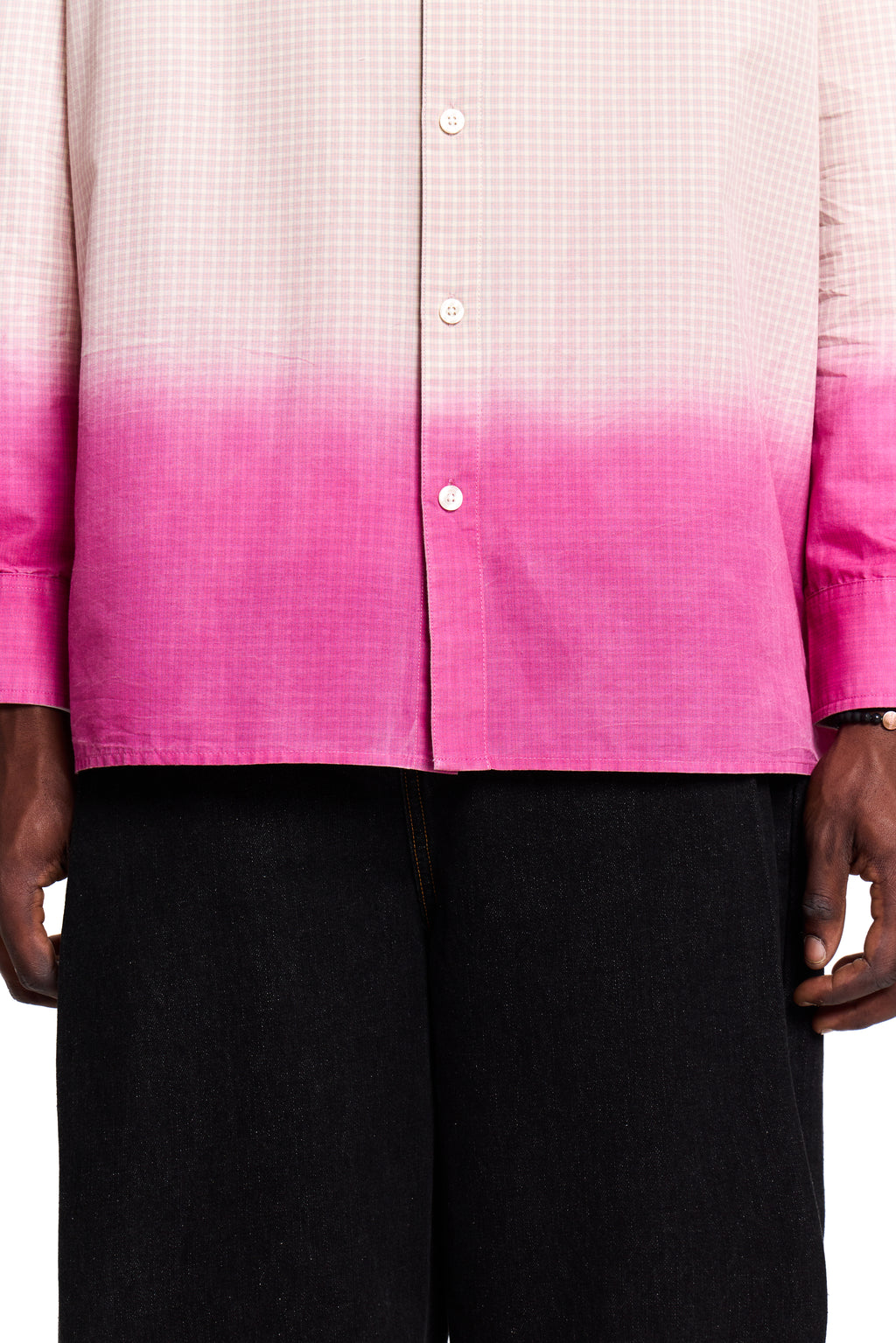 Person wearing a pink and white Boy London gradient shirt with black pants on a white background