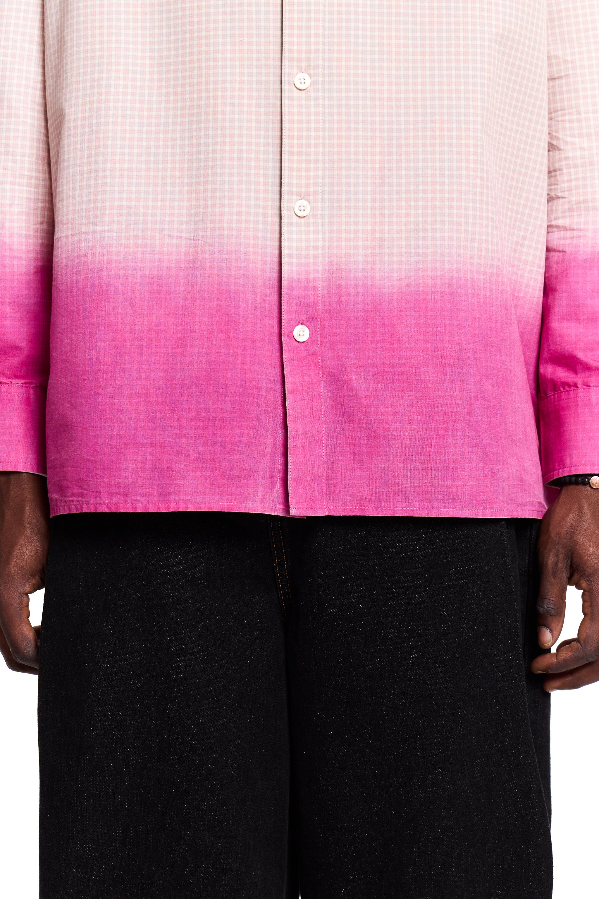 Person wearing a pink and white Boy London gradient shirt with black pants on a white background
