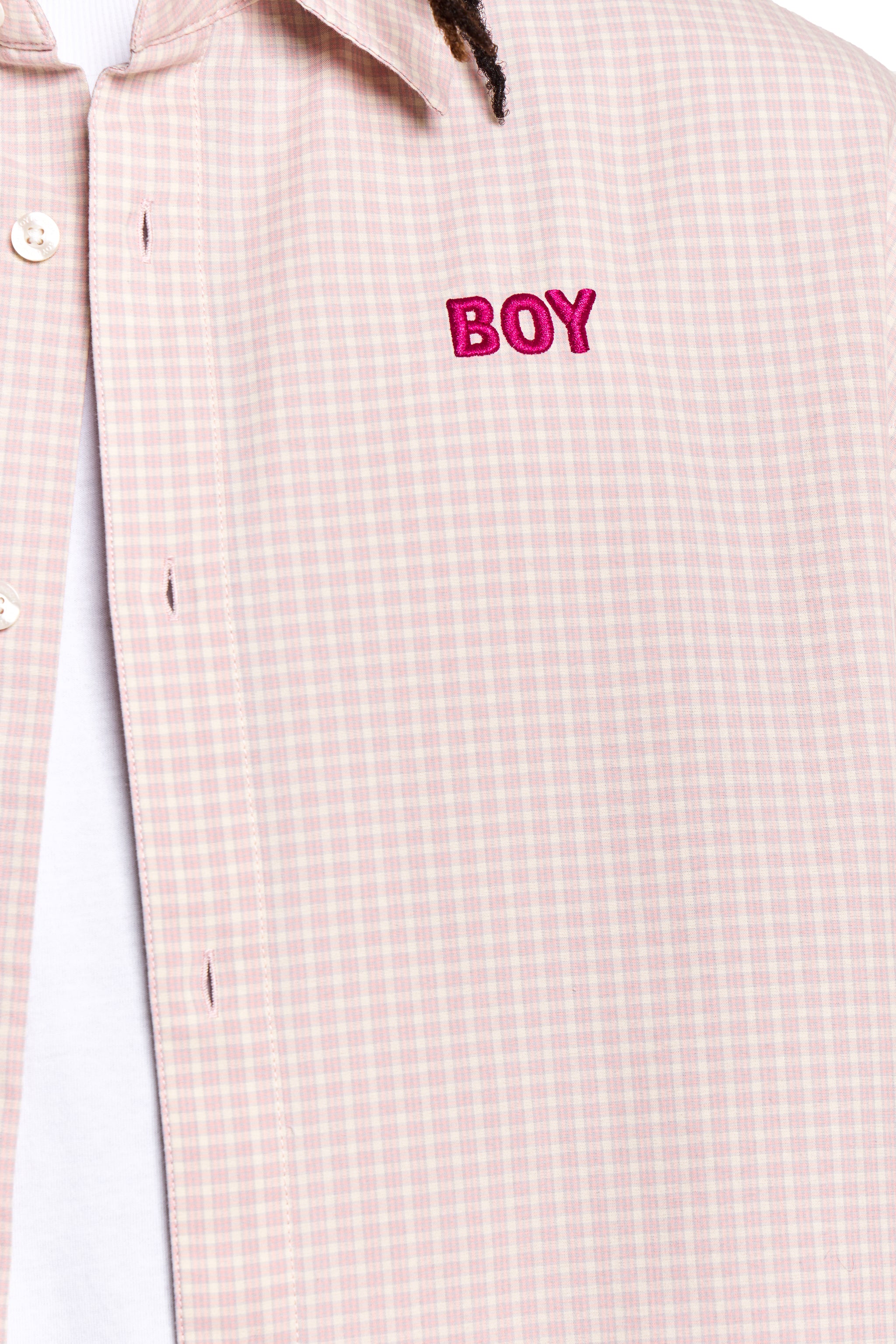 Close-up of a checkered shirt with 'BOY' embroidered on it.
