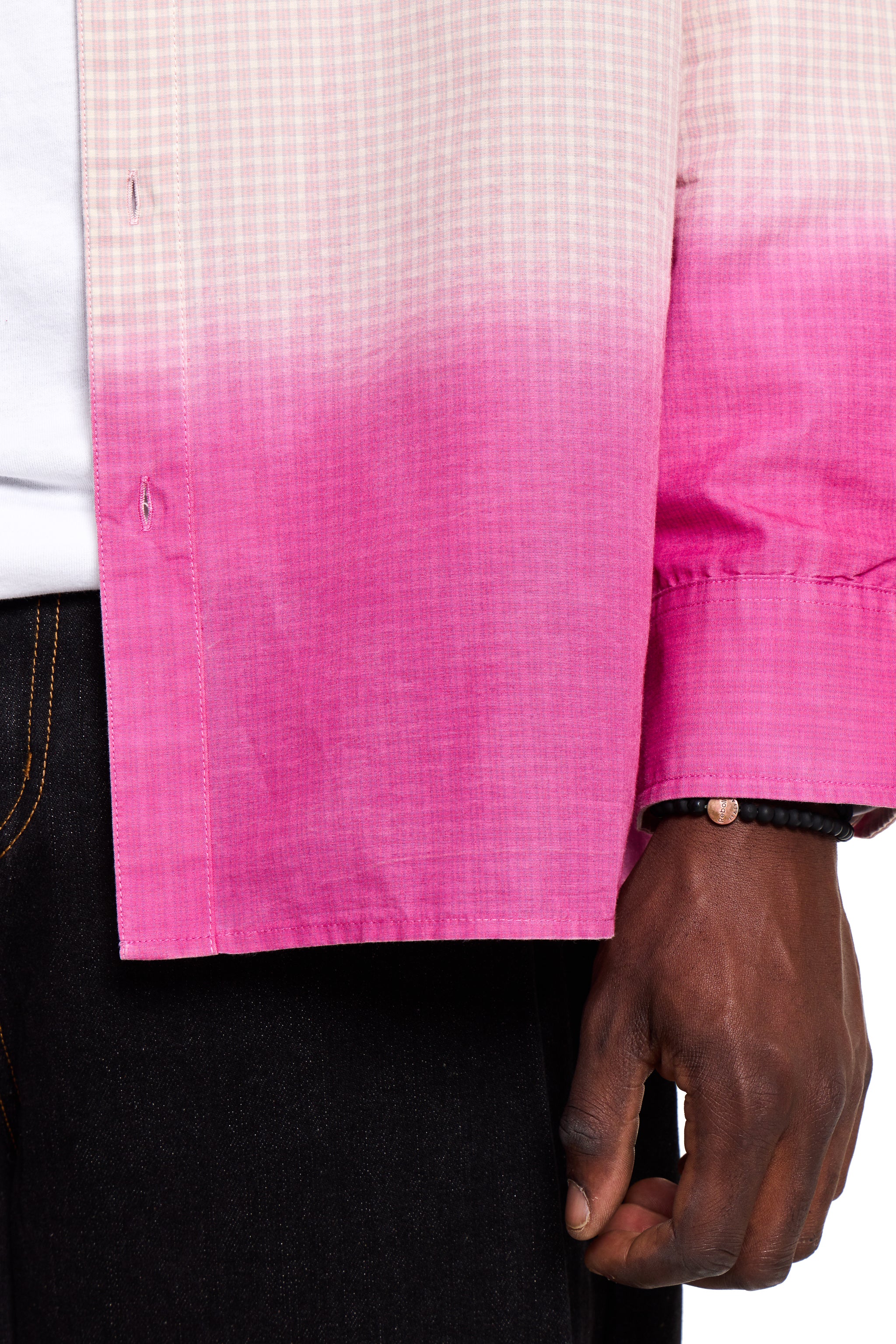 Close-up of a person wearing a Boy London pink and white checkered shirt with a gradient effect.