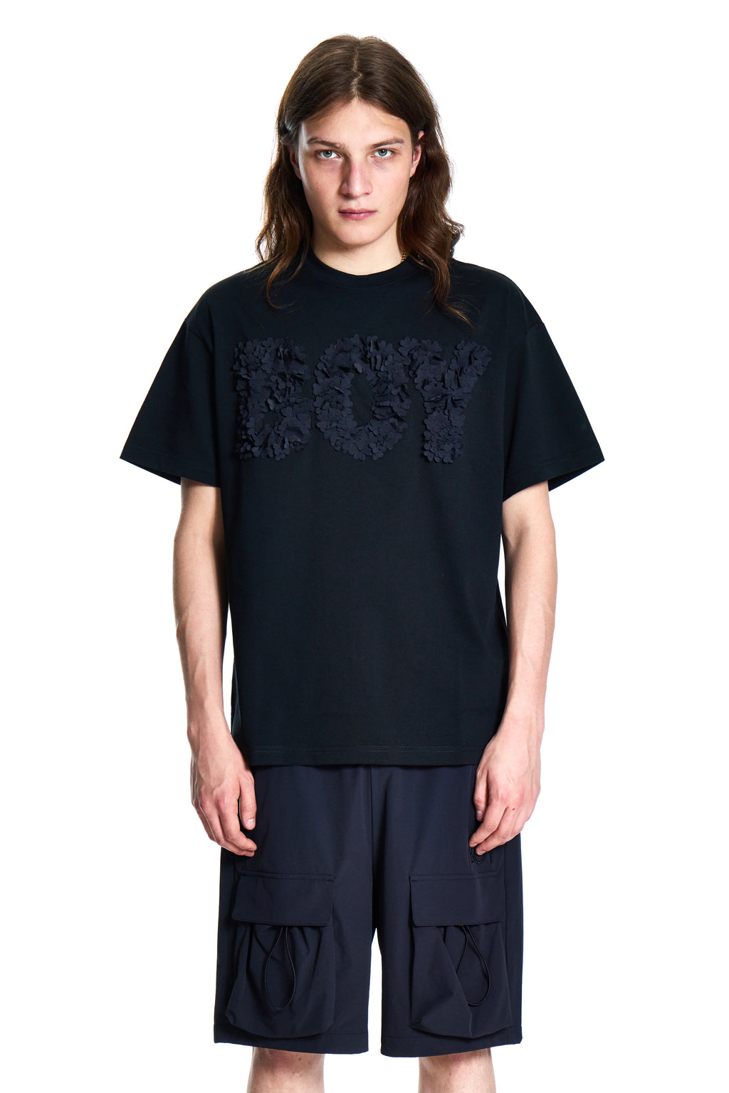 Person wearing a black BOY London t-shirt and shorts set on a white background
