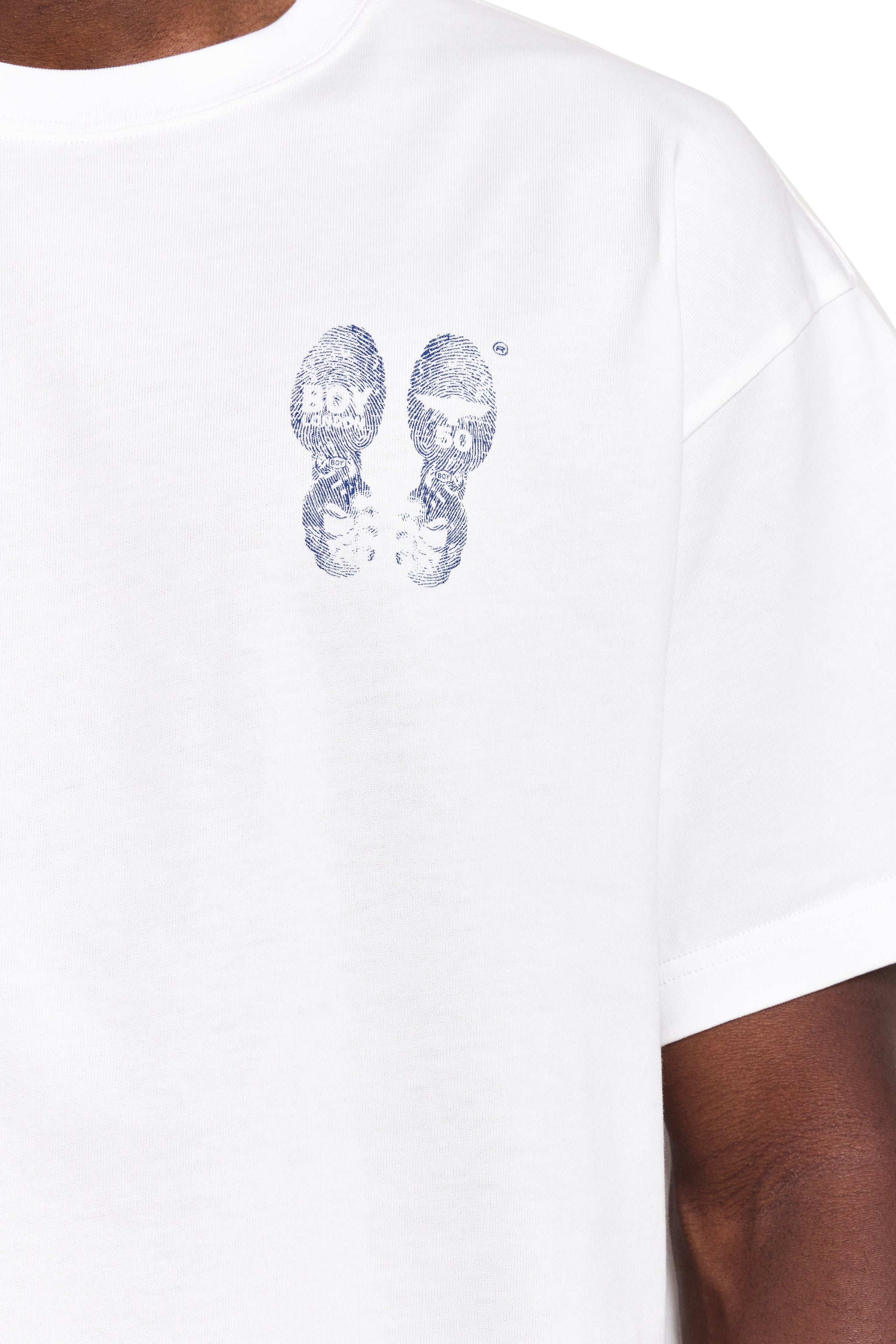 White t-shirt with blue shoe print design on a white background