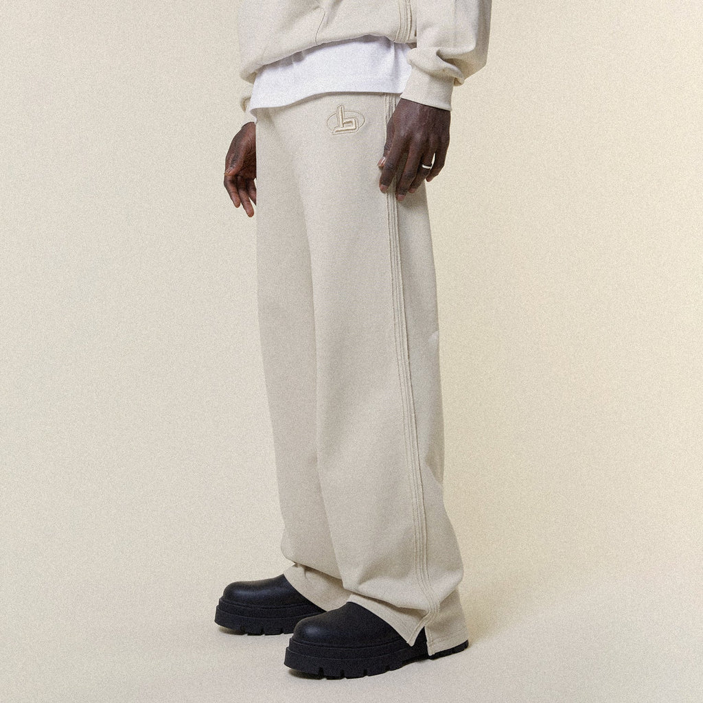 Beige pants with a BOY London logo on a white background