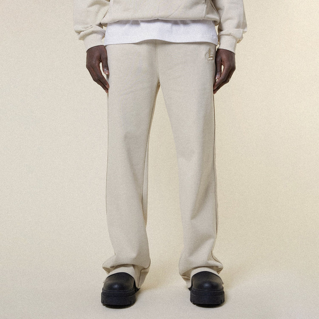 Beige pants with a BOY London logo on a white background